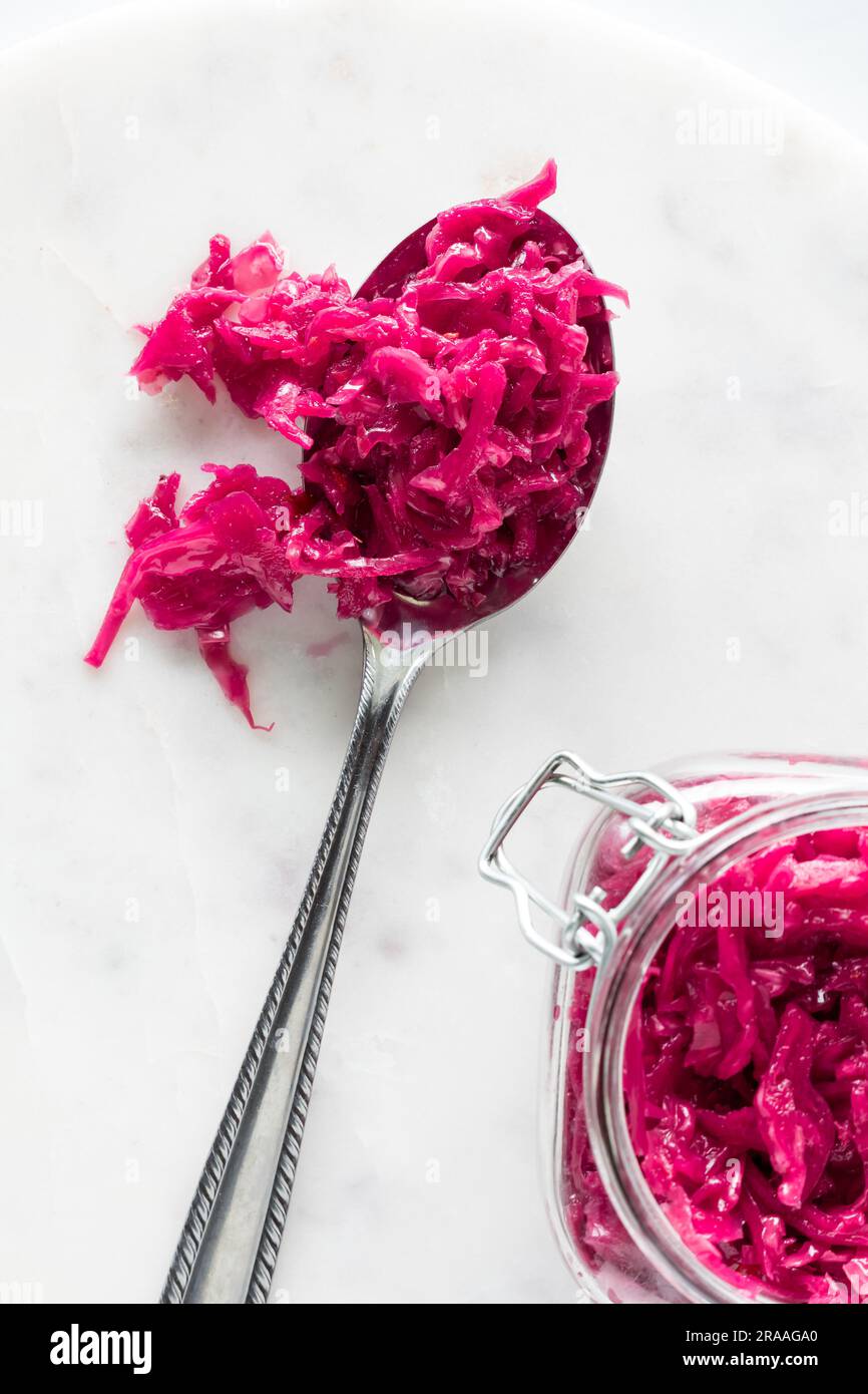 Above view of a spoon heaped with pickled beet and cabbage sauerkraut