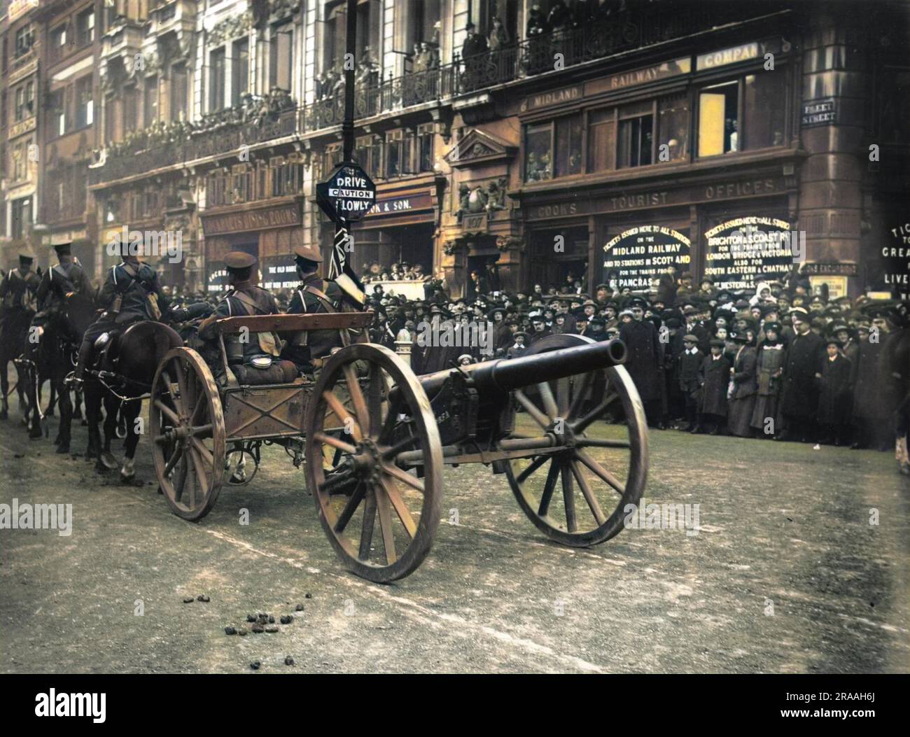 World War One artillery moving down a London street, as a crowd looks on.     Date: C. 1914 Stock Photo