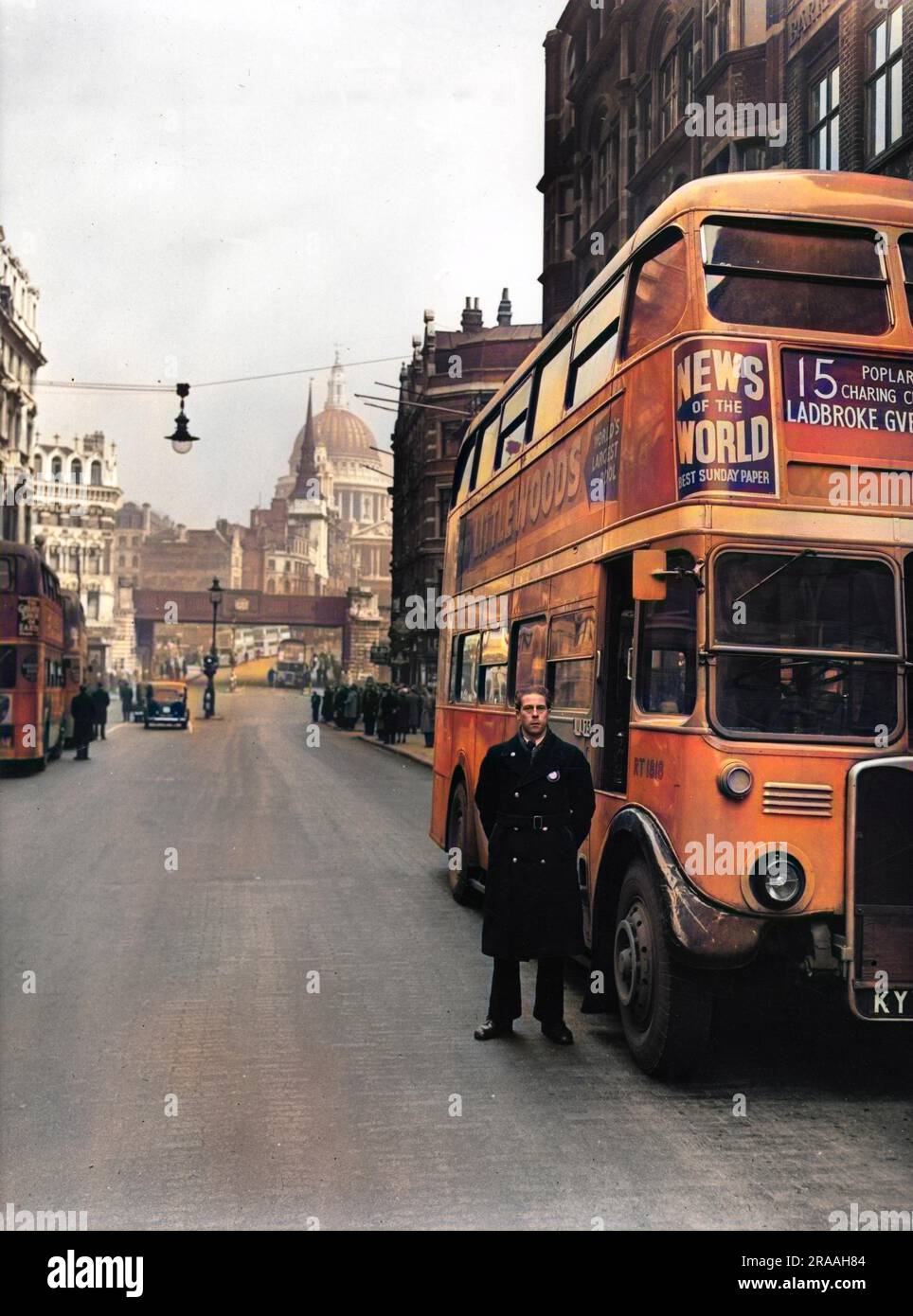 The number 15 bus and bus driver in London. Ludgate train bridge and St Pauls Cathedral can be seen in the background. Stock Photo