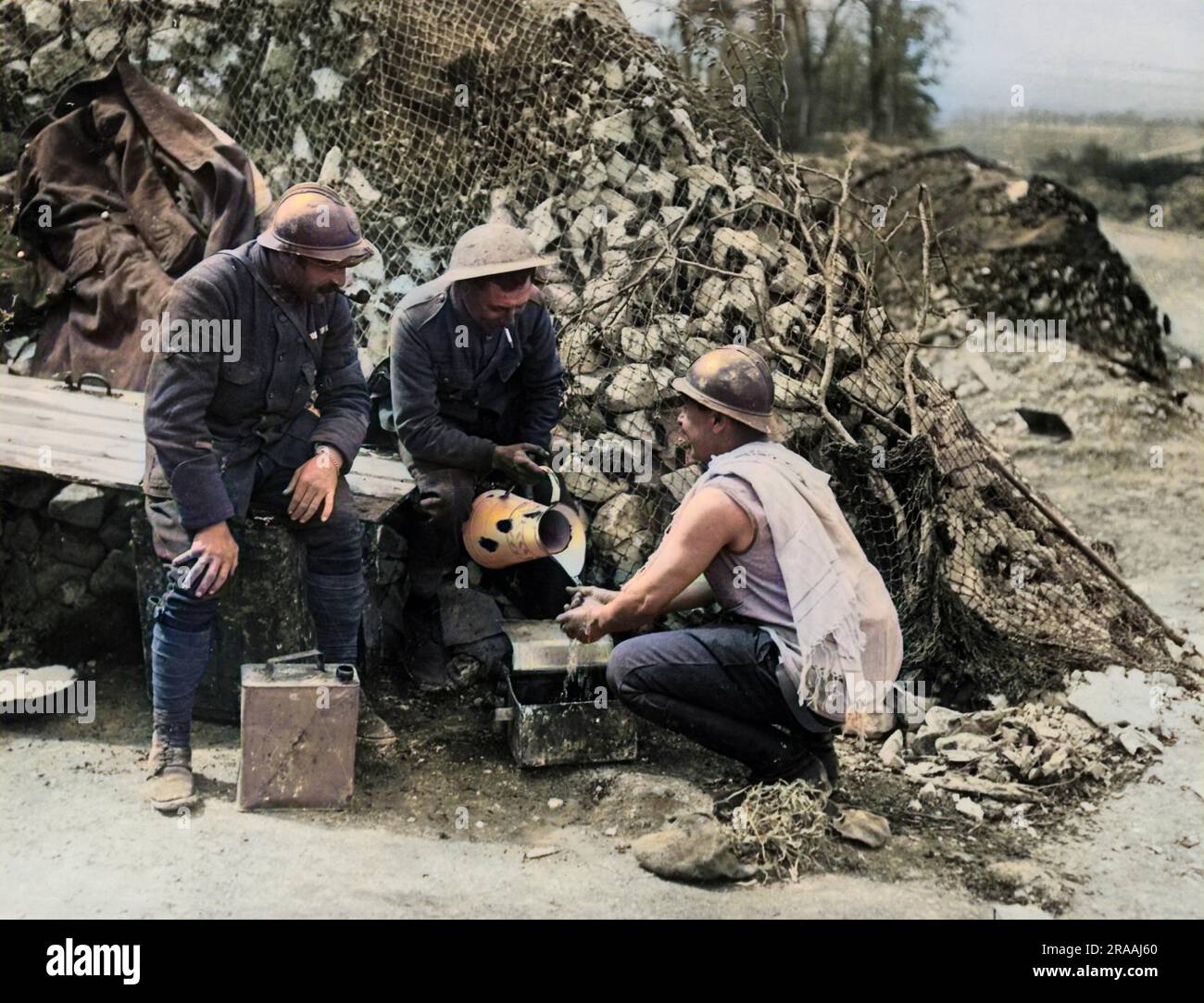 A British soldier helping a French soldier with his morning wash on the Western Front in France during World War One.     Date: circa 1916 Stock Photo
