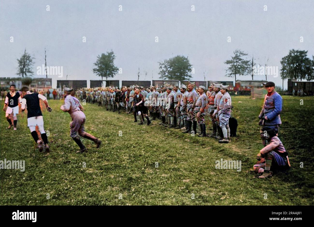 British and French soldiers playing and watching football on the Western Front in France during World War One.  The British team are in black and white.     Date: circa 1916 Stock Photo