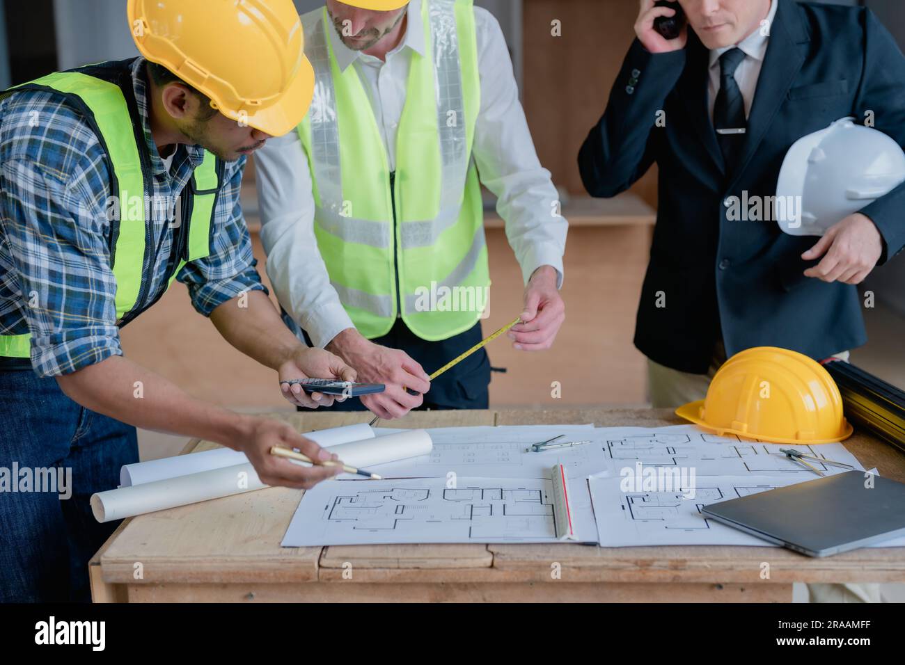 multi ethnic engineer brainstorming and measuring for cost estimating