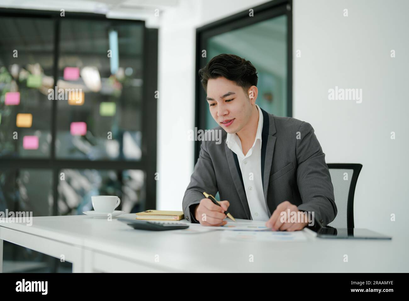 businessman or accountant working on calculator and laptop computer to calculate business data during using accountancy document at office. Stock Photo