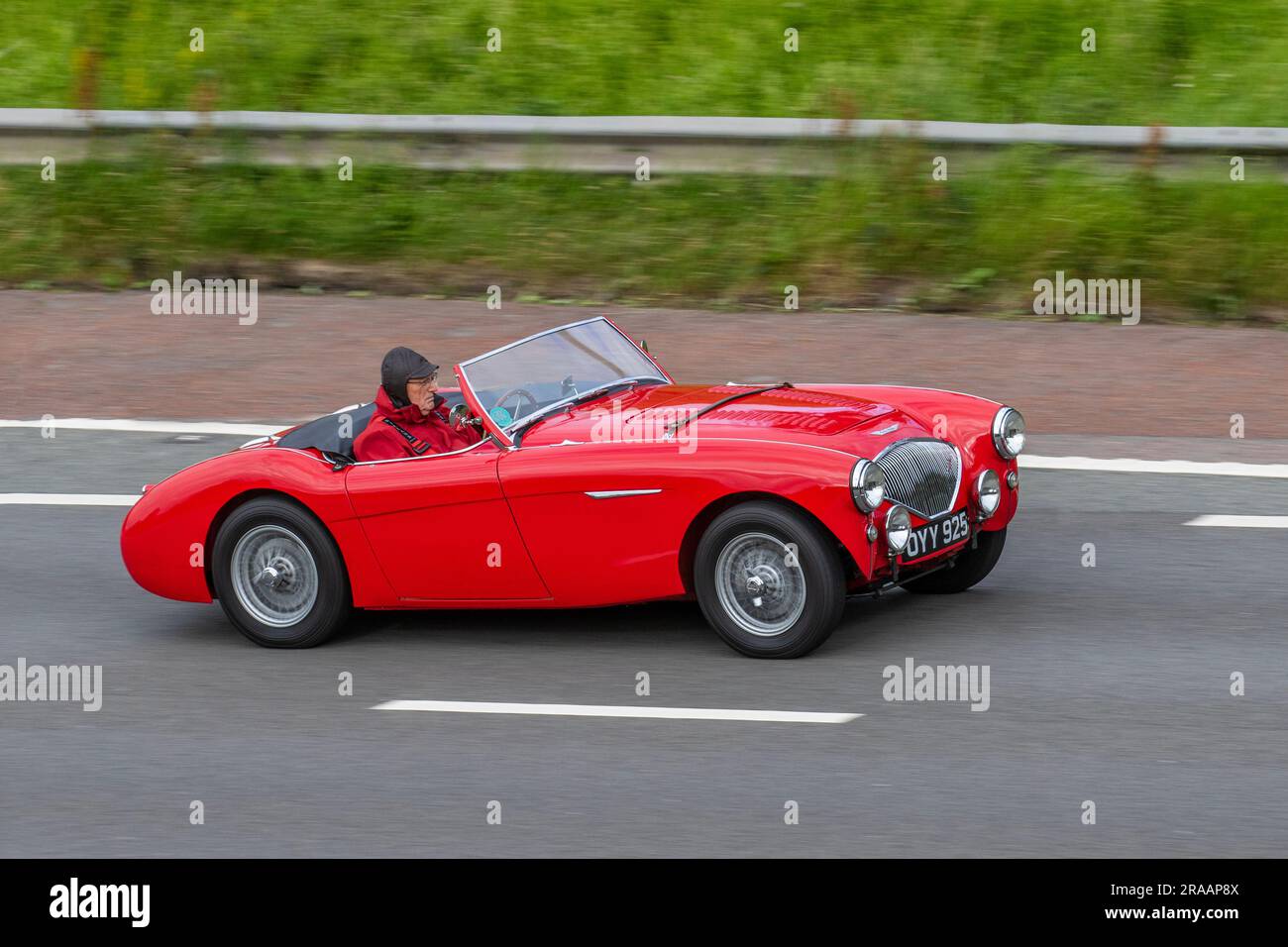 1954, 50s fifties Austin Healey Red Car Petrol 2660 cc sports cabriolet; travelling at speed on the M6 motorway in Greater Manchester, UK Stock Photo