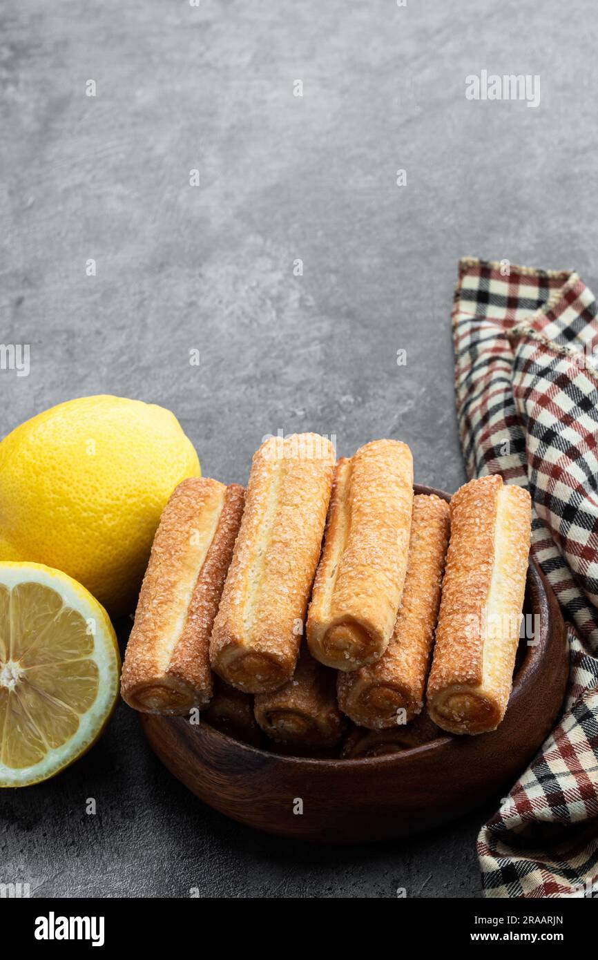 Homemade  lemon jam filled sticks in wooden bowl on gray background Stock Photo