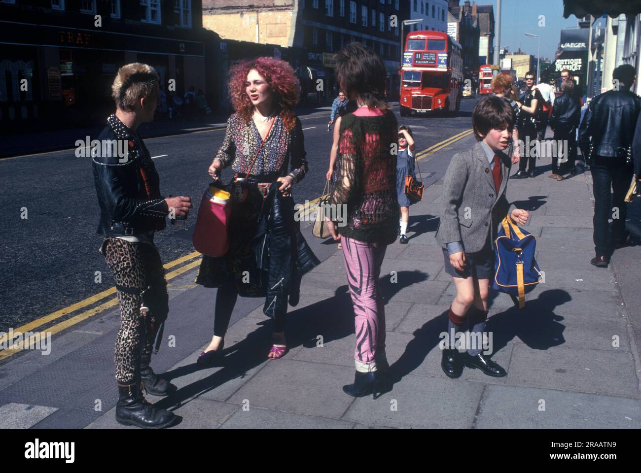1970s Punks teenage fashion Chelsea, London. The Kings Road, Chelsea, Saturday morning three punks stop and chat, a young school boy in his school uniform walks by. England 1979. UK HOMER SYKES Stock Photo