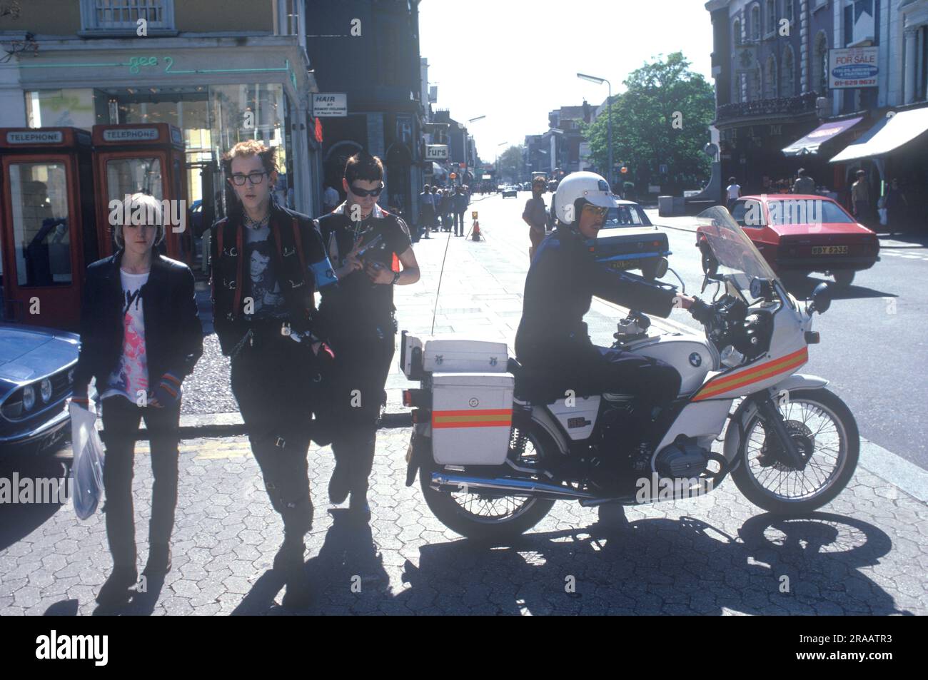 1970s Punk street fashion Chelsea, street fashion in the Kings Road, three punks and a policeman on a motorbike. London, England 1979. UK HOMER SYKES Stock Photo