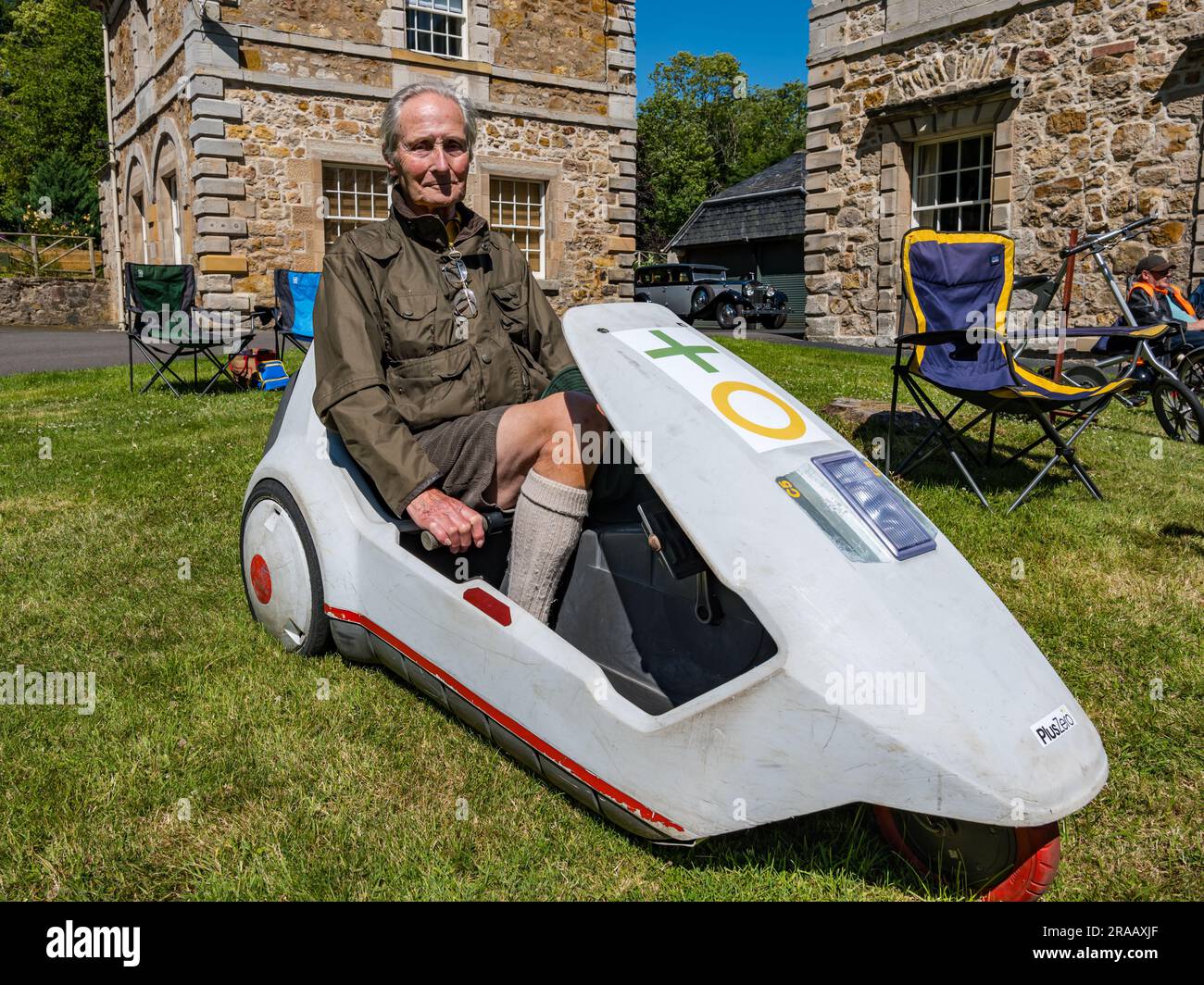 East Lothian, Scotland, UK, 2nd July 2023. Wheels of Yesteryear: the Scottish Association of Vehicle Enthusiasts annual jaunt takes owners of vintage vehicles through the countryside to the scenic grounds of Lennoxlove House. Pictured: an elderly man sits in a Sinclair C5 bicycle. Credit: Sally Anderson/Alamy Live News Stock Photo