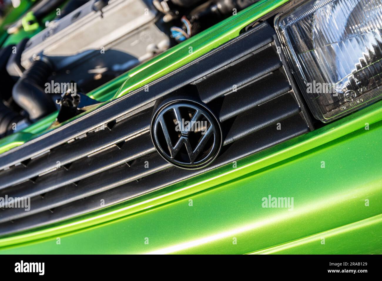 Berlin, Germany - June 24, 2023: Volkswagen logo on a green tuned Volkswagen car at a meadow. Stock Photo