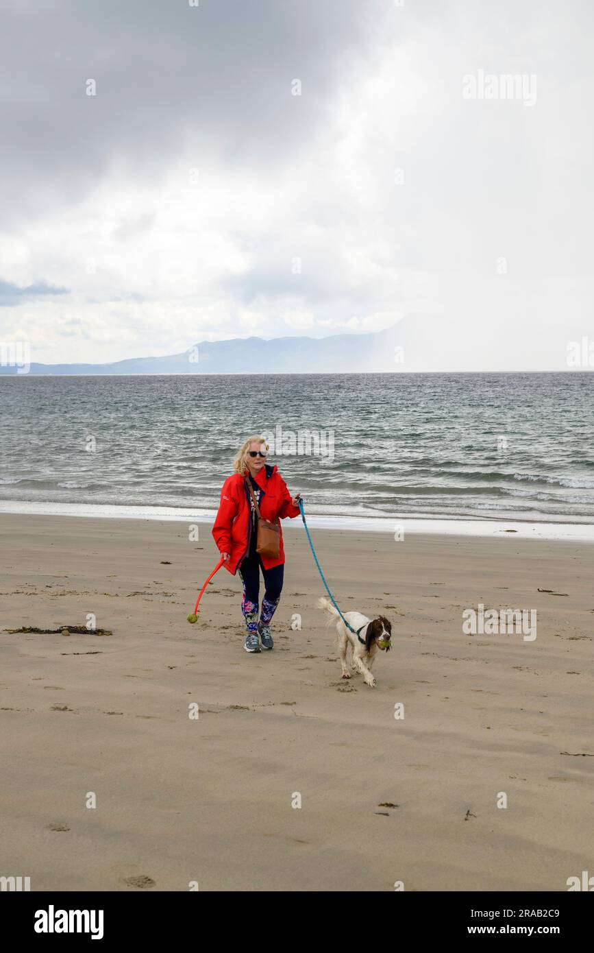 Woman with dog on Mallaranny Beach, County Mayo, Ireland Stock Photo