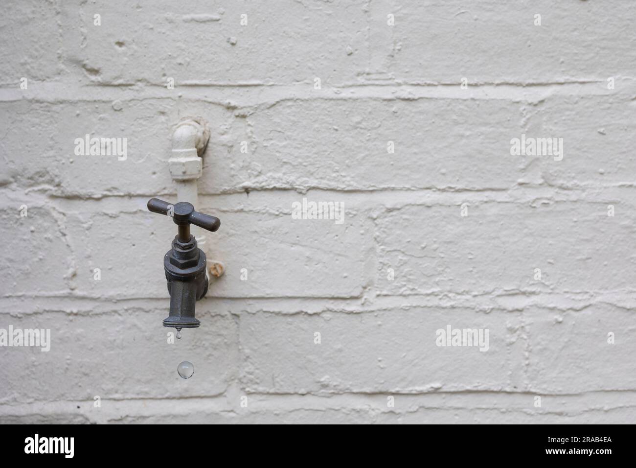 External water tap outside of a house with water drip Stock Photo