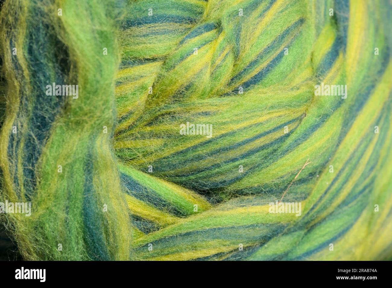 Multicolored strings of wool for felting and spinning as a background. Stock Photo