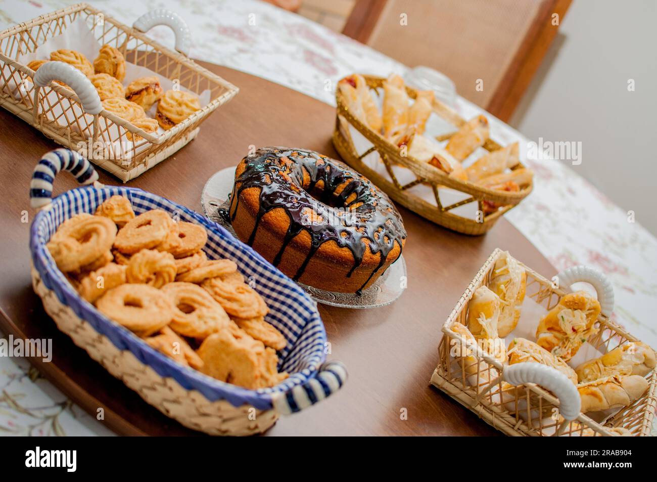 Photo of vanilla cake with chocolate frosting laid out on a table. Table with goodies. Stock Photo