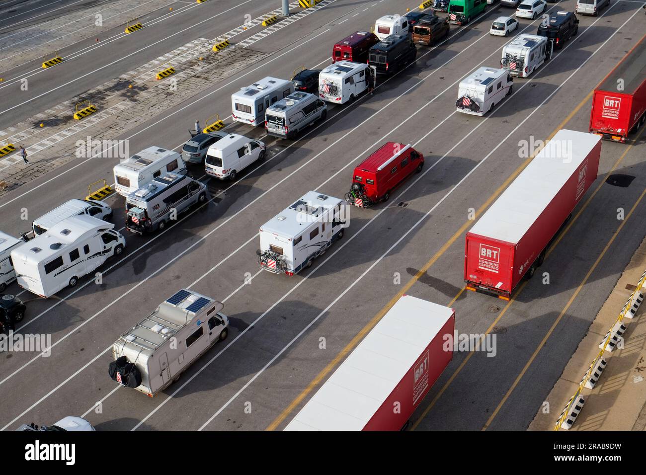 Cars, camper vans and homes and lorries waiting to get loaded onto a ferry from the port of Olbia, Sardinia, Italy Stock Photo