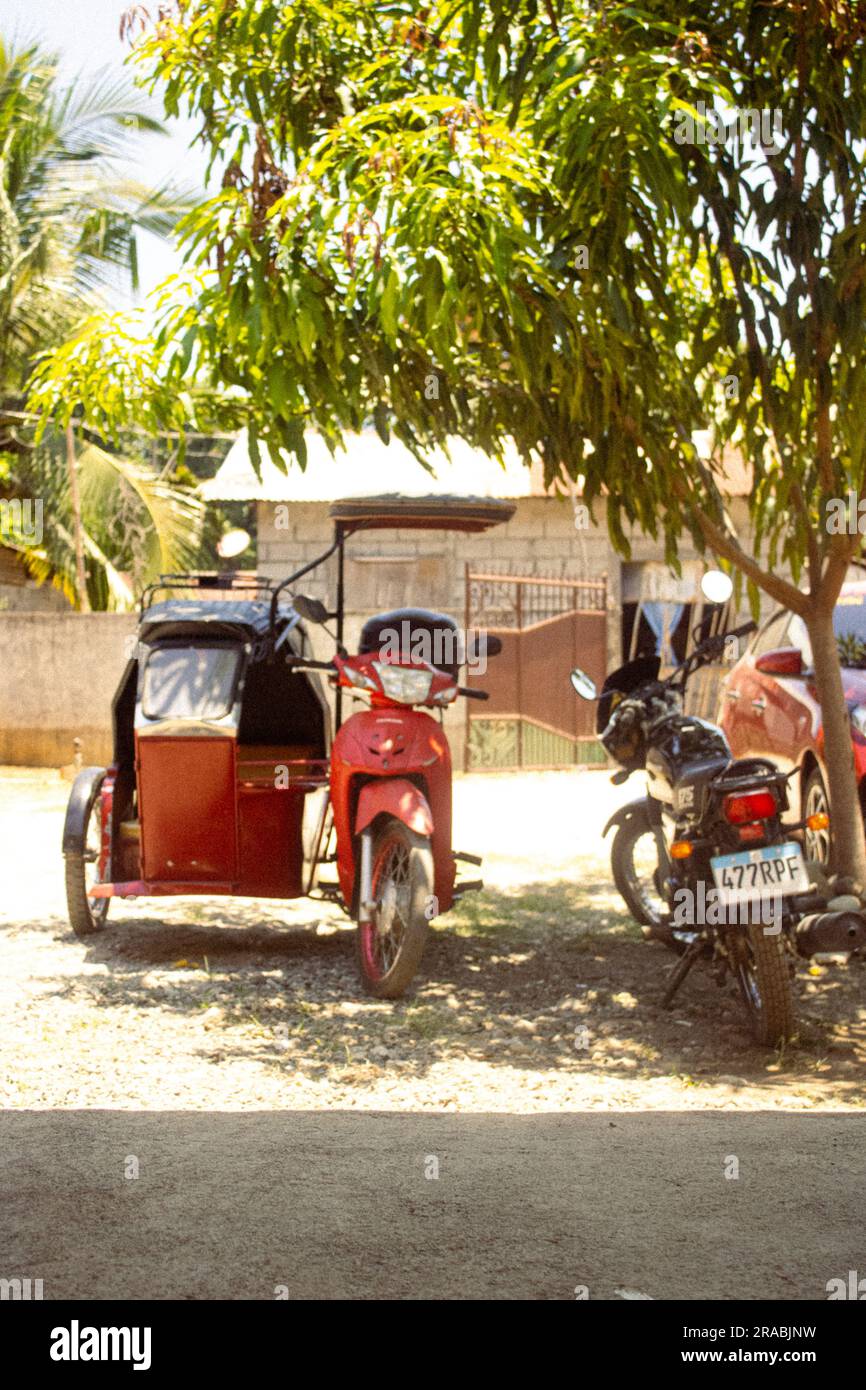 A red tricycle parked underneath a tree in Iba, Zambales, Philippines Stock Photo Alamy