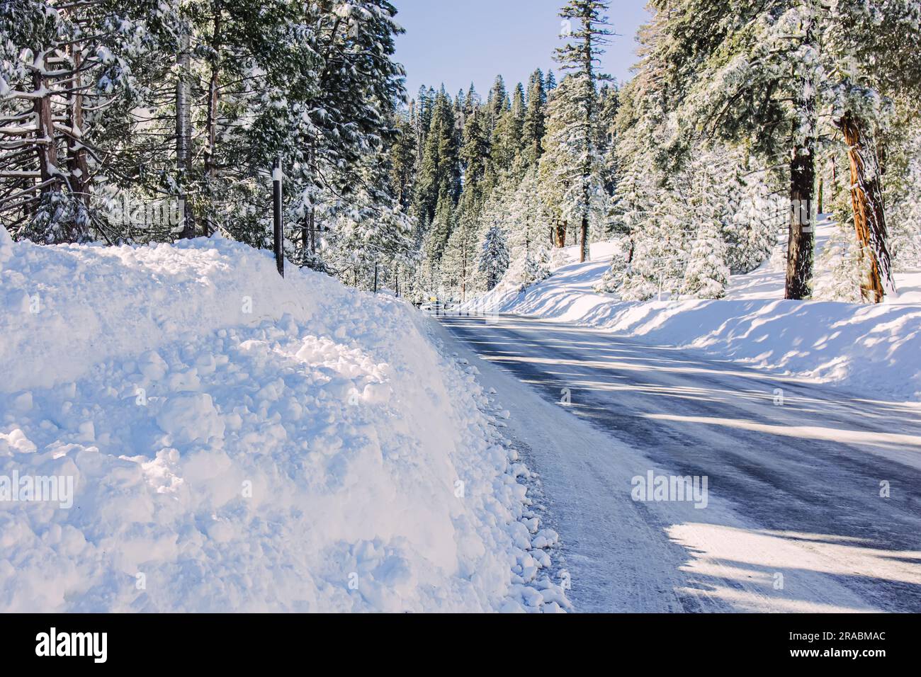 Winter road with lots of snow on the roadsides, driving on snowy roads Stock Photo