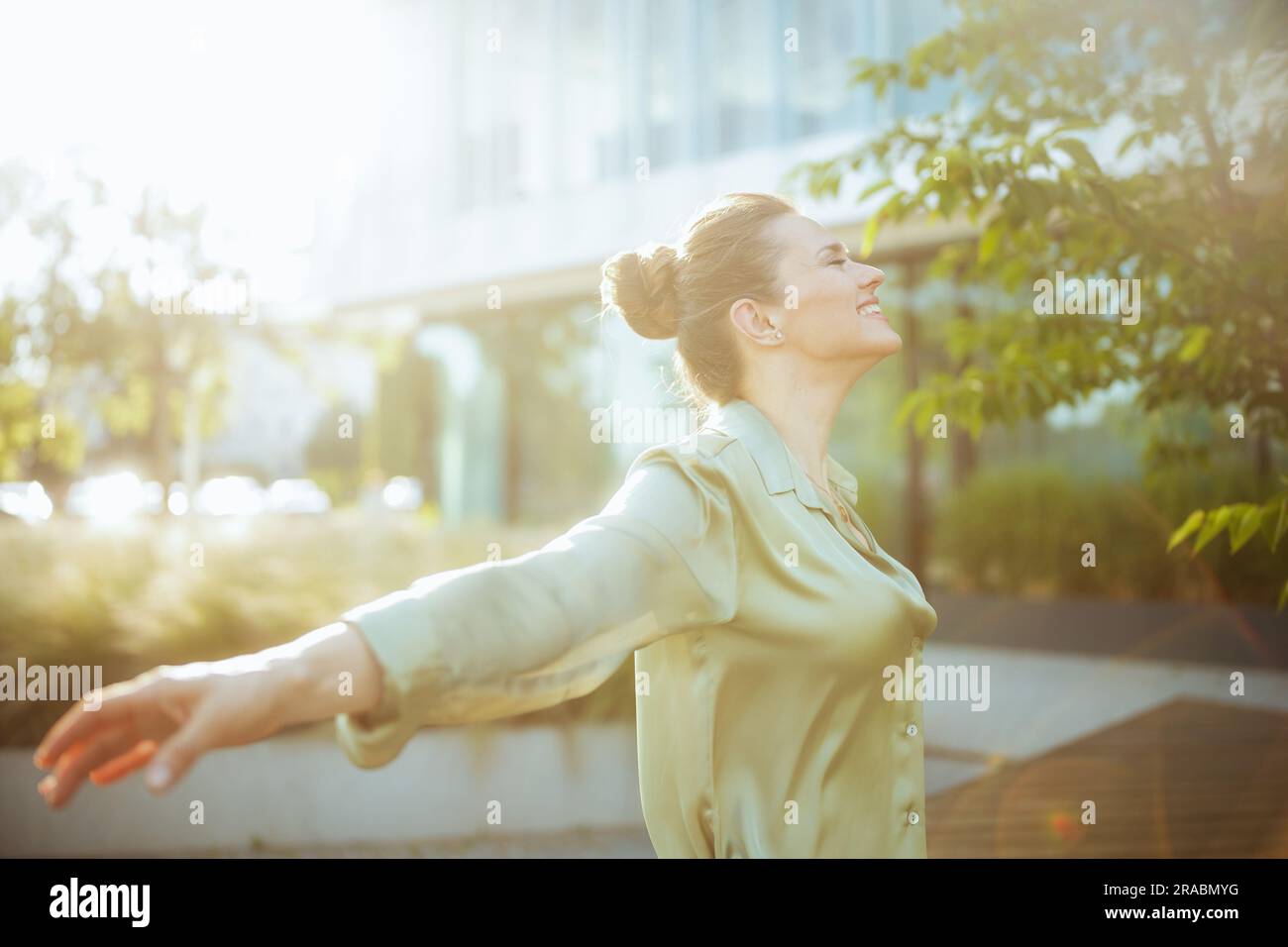 happy modern female worker near office building in green blouse ...