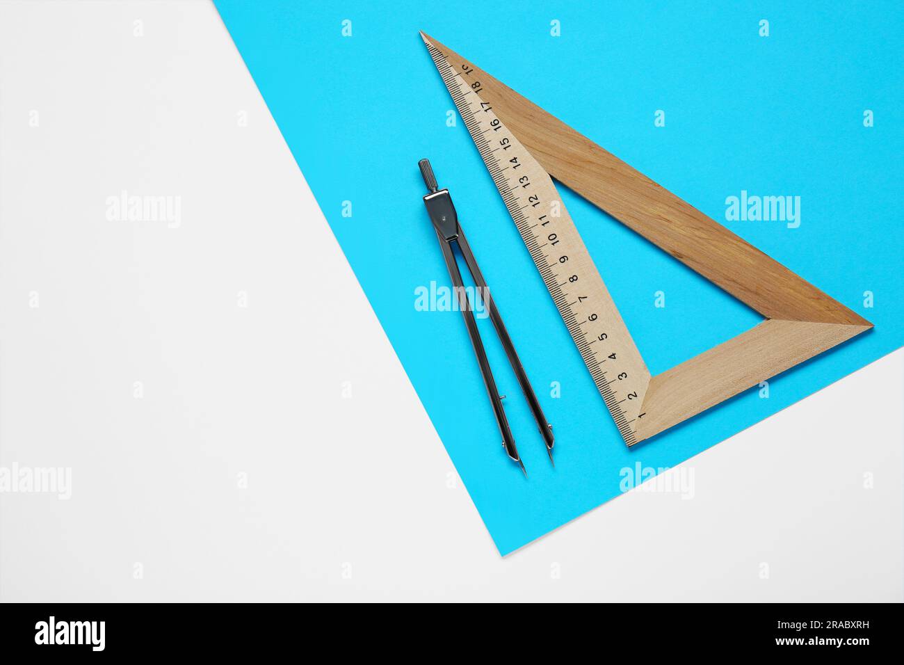 Triangle ruler, paper sheet and compass on white background, flat lay ...