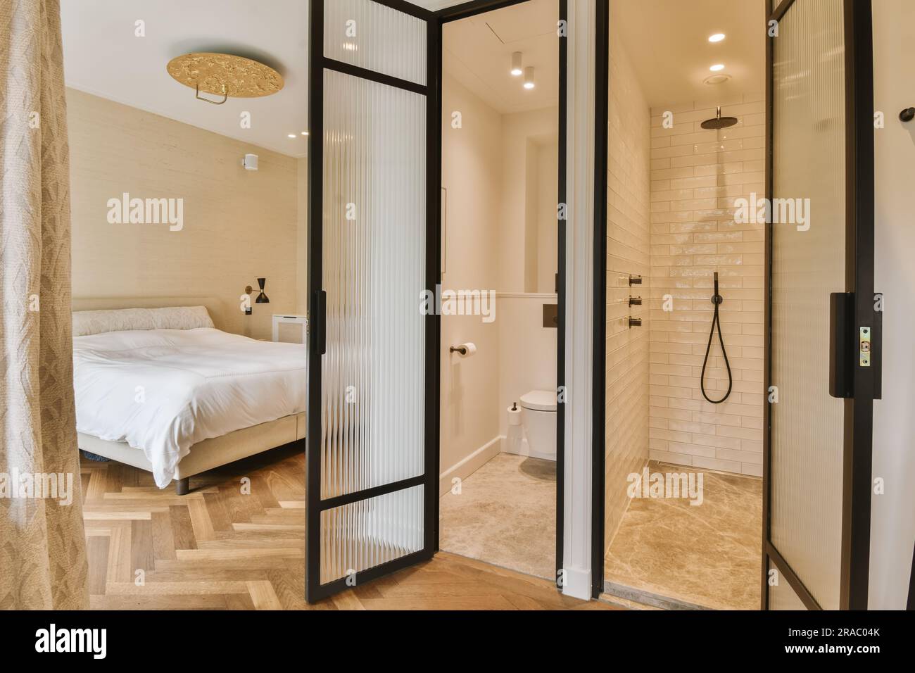 a bathroom with a bed in the corner and shower doors open to reveal a — free download