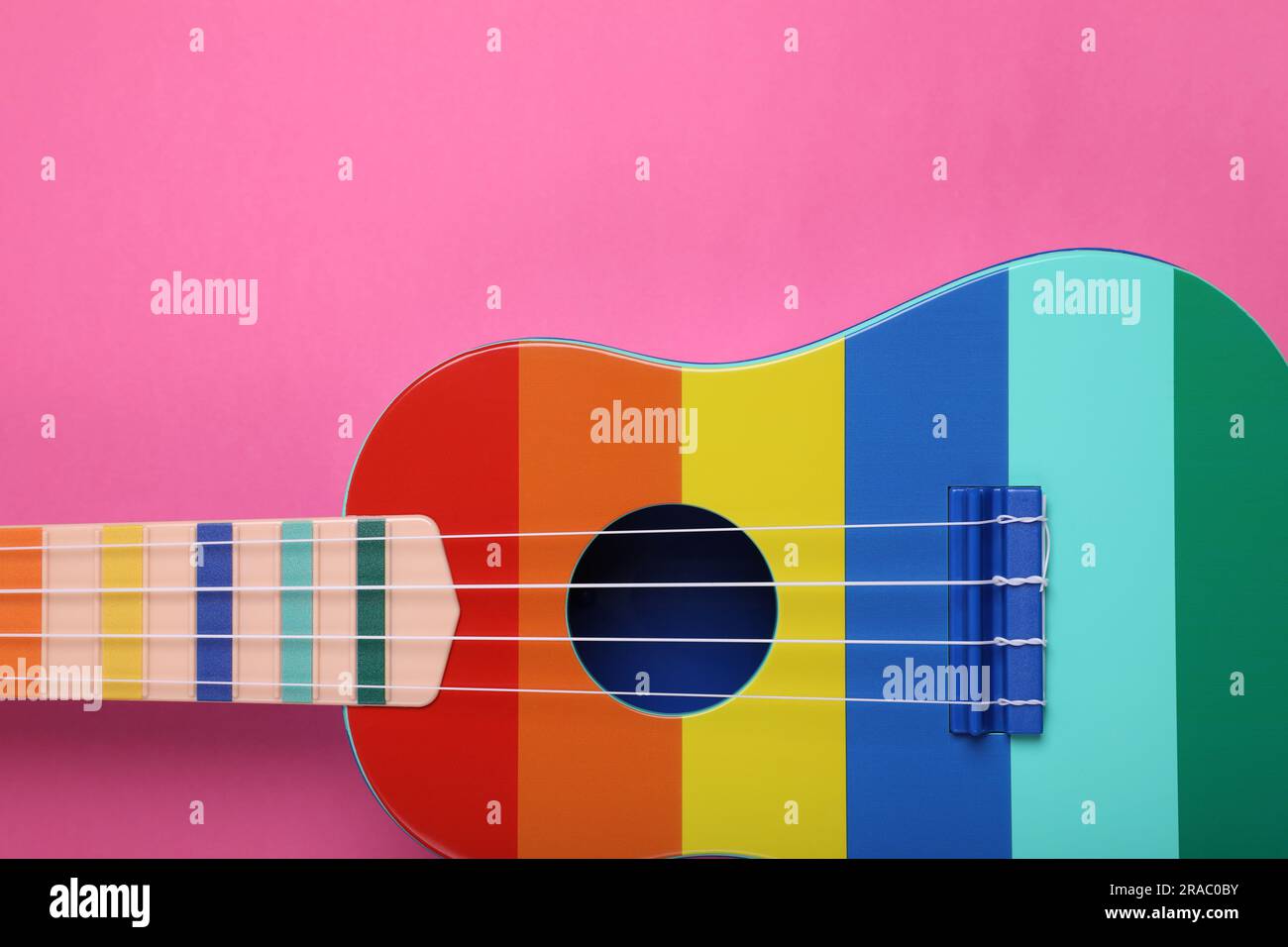 Colorful ukulele on pink background, top view. String musical ...
