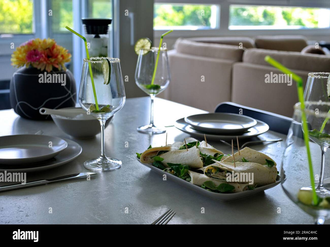 Plate with tortilla and glasses for cocktail on a table at home Stock Photo