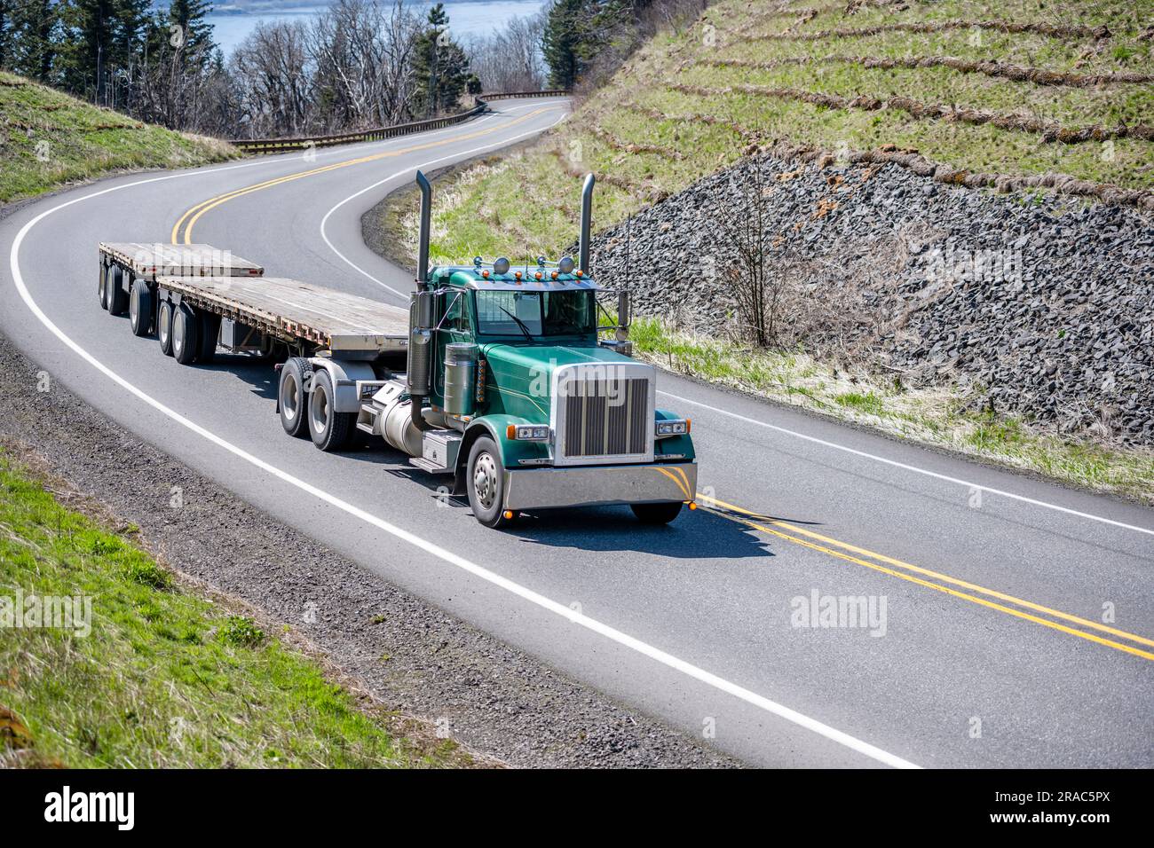 Industrial green big rig day cab semi truck tractor transporting two