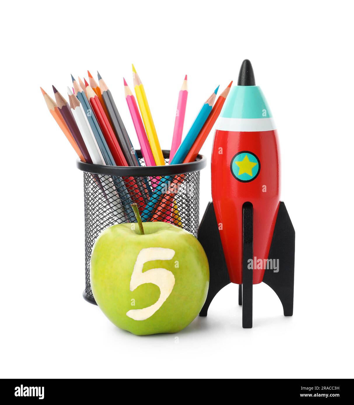 Apple with carved number five as school grade. Bright toy rocket and pencils on white background Stock Photo
