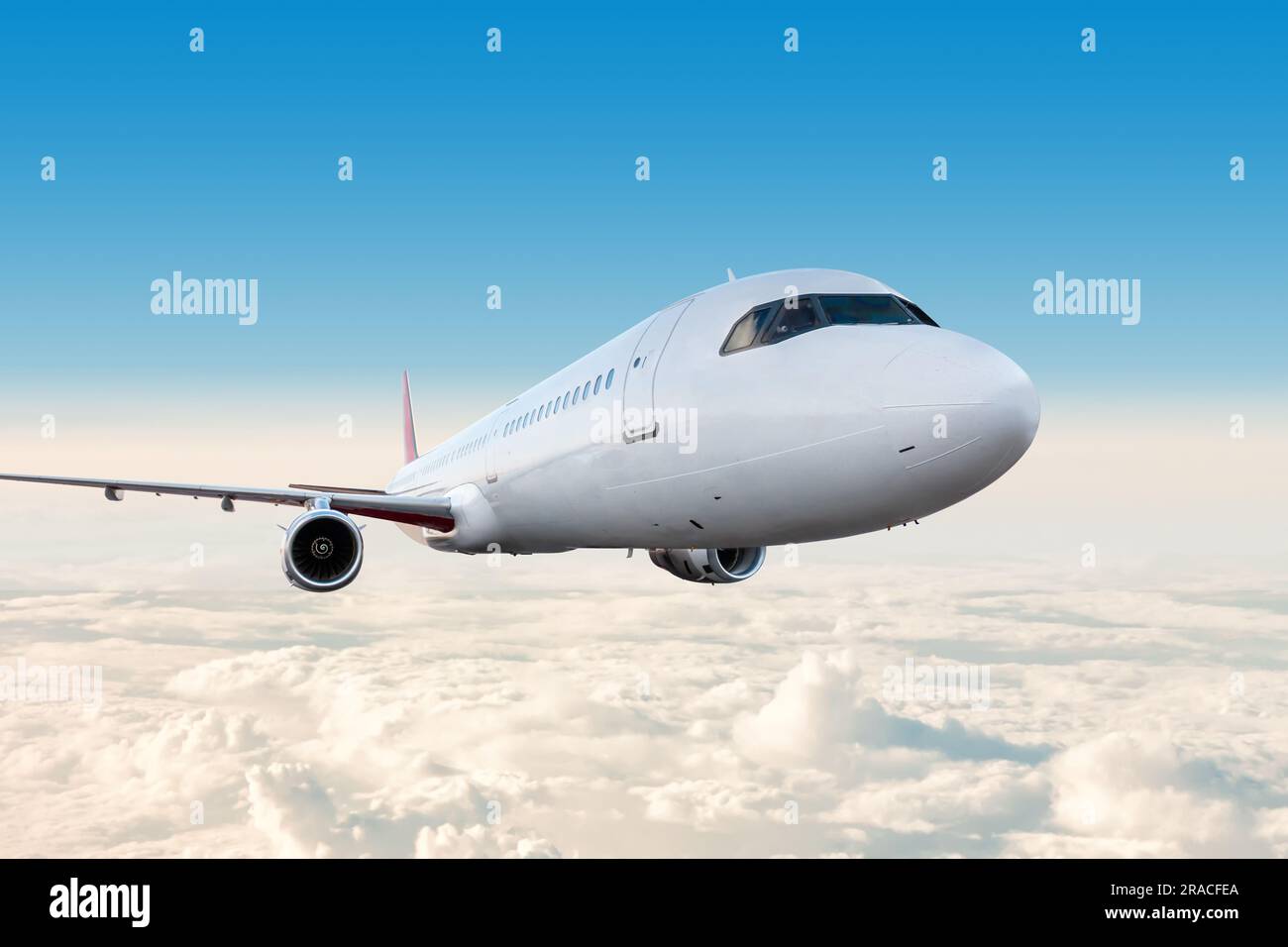 Modern white passenger airplane flying in the sky Stock Photo - Alamy