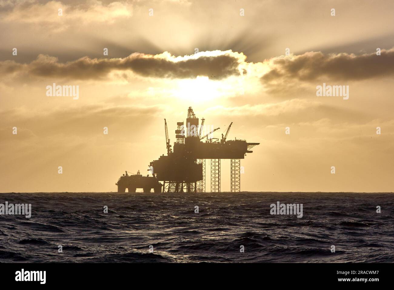 Silhouette of a jack up drilling rig in the North Sea at sunset. North sea offshore platform for oil and gas. Stock Photo