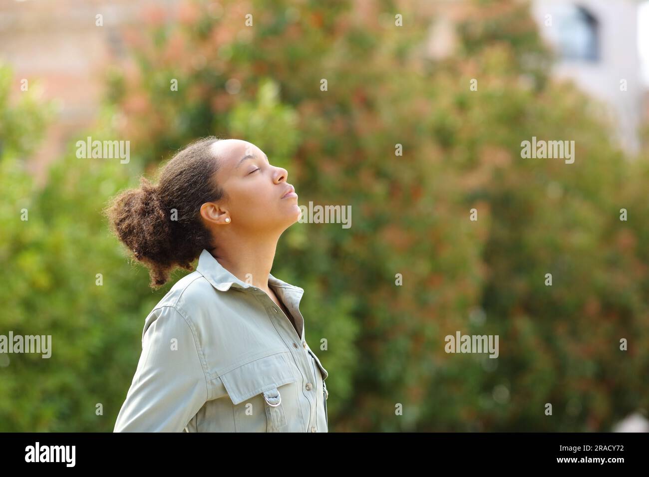 Profile of black woman meditating breathing fresh air in a park Stock ...