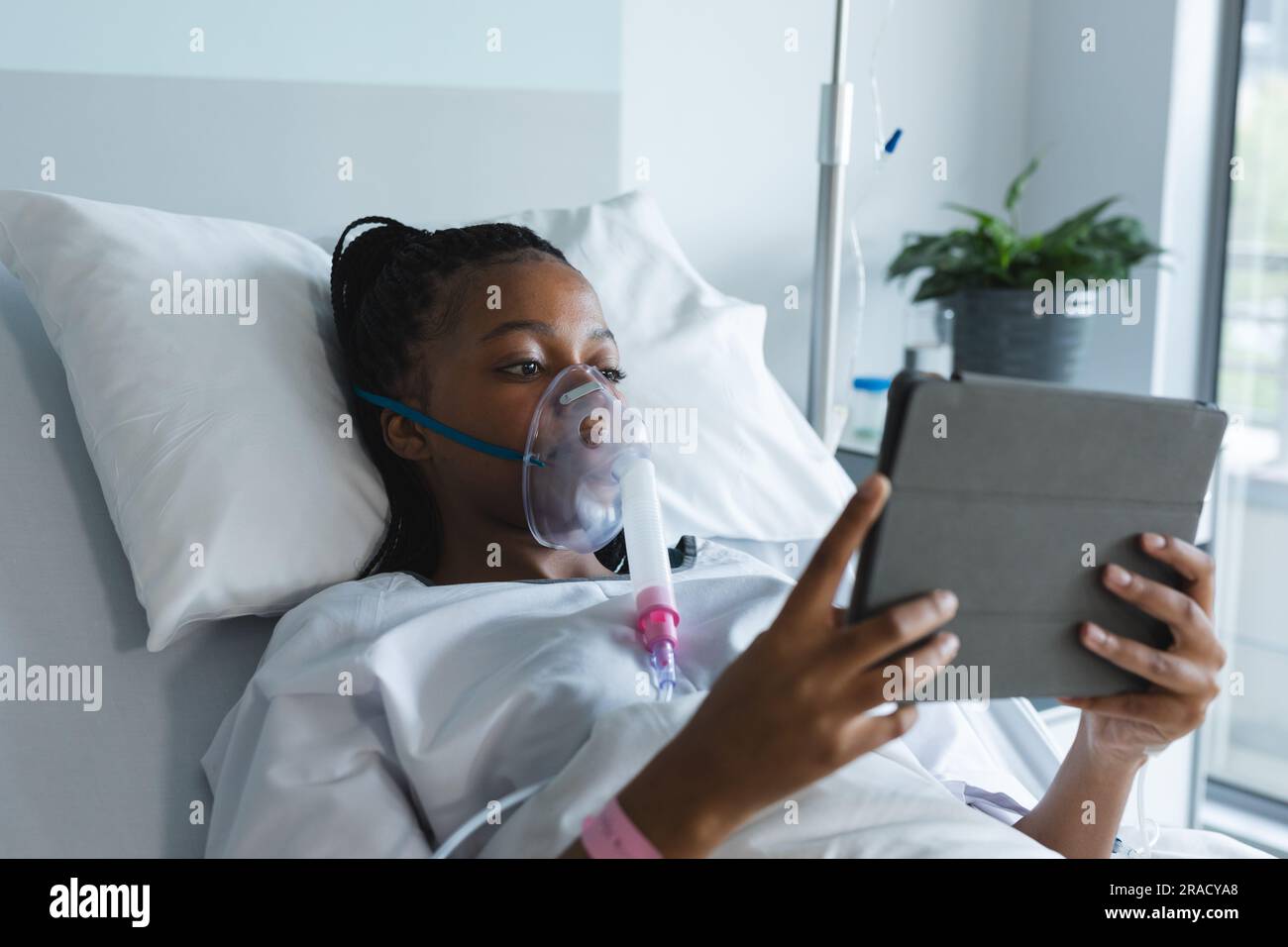 African american female patient with oxygen mask lying on bed and