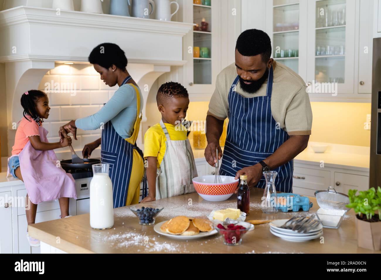 https://c8.alamy.com/comp/2RAD0CN/african-american-father-and-son-mixing-batter-in-bowl-while-mother-and-daughter-cooking-pancakes-2RAD0CN.jpg
