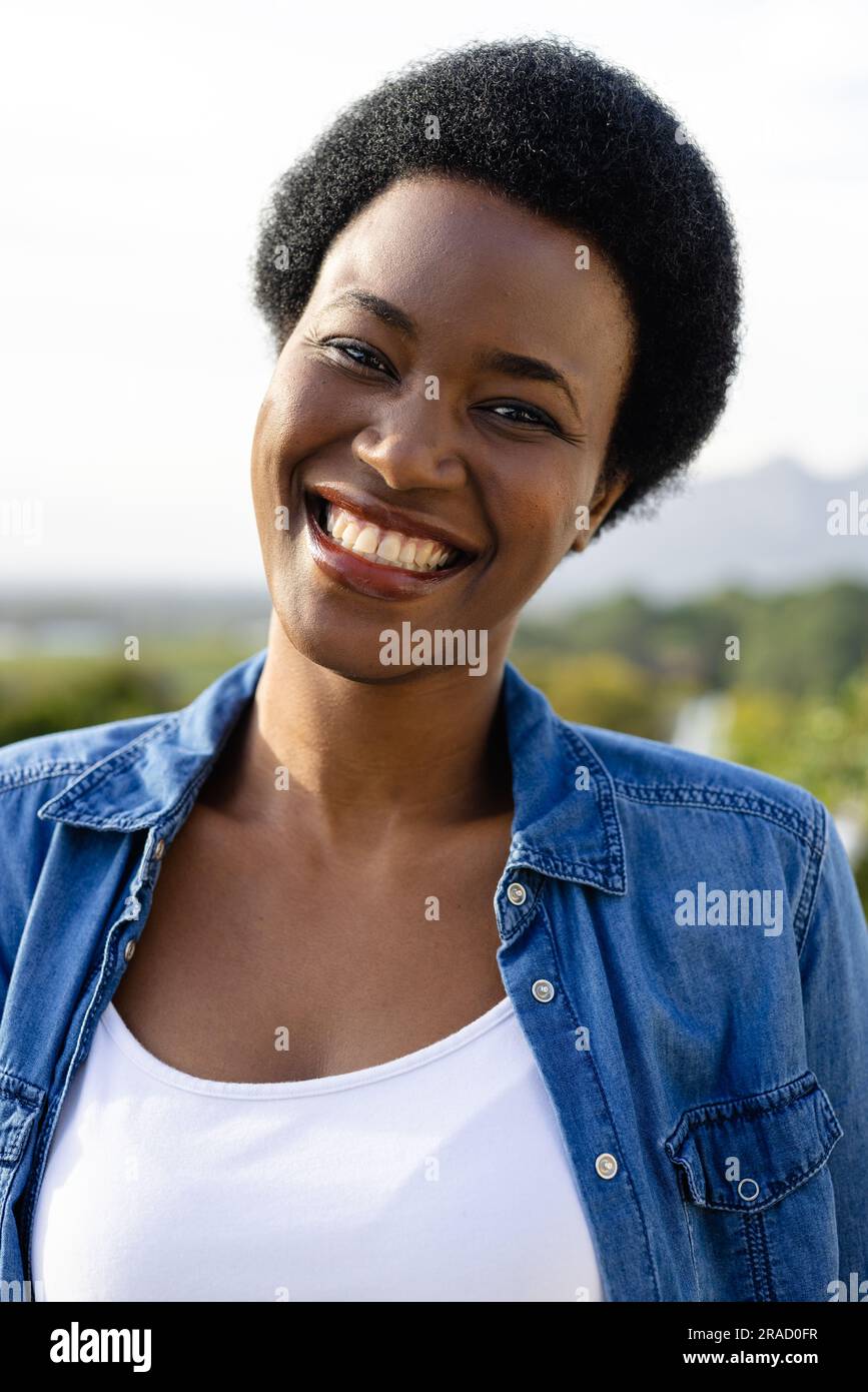 Portrait of happy african american woman on sunny terrace Stock Photo ...