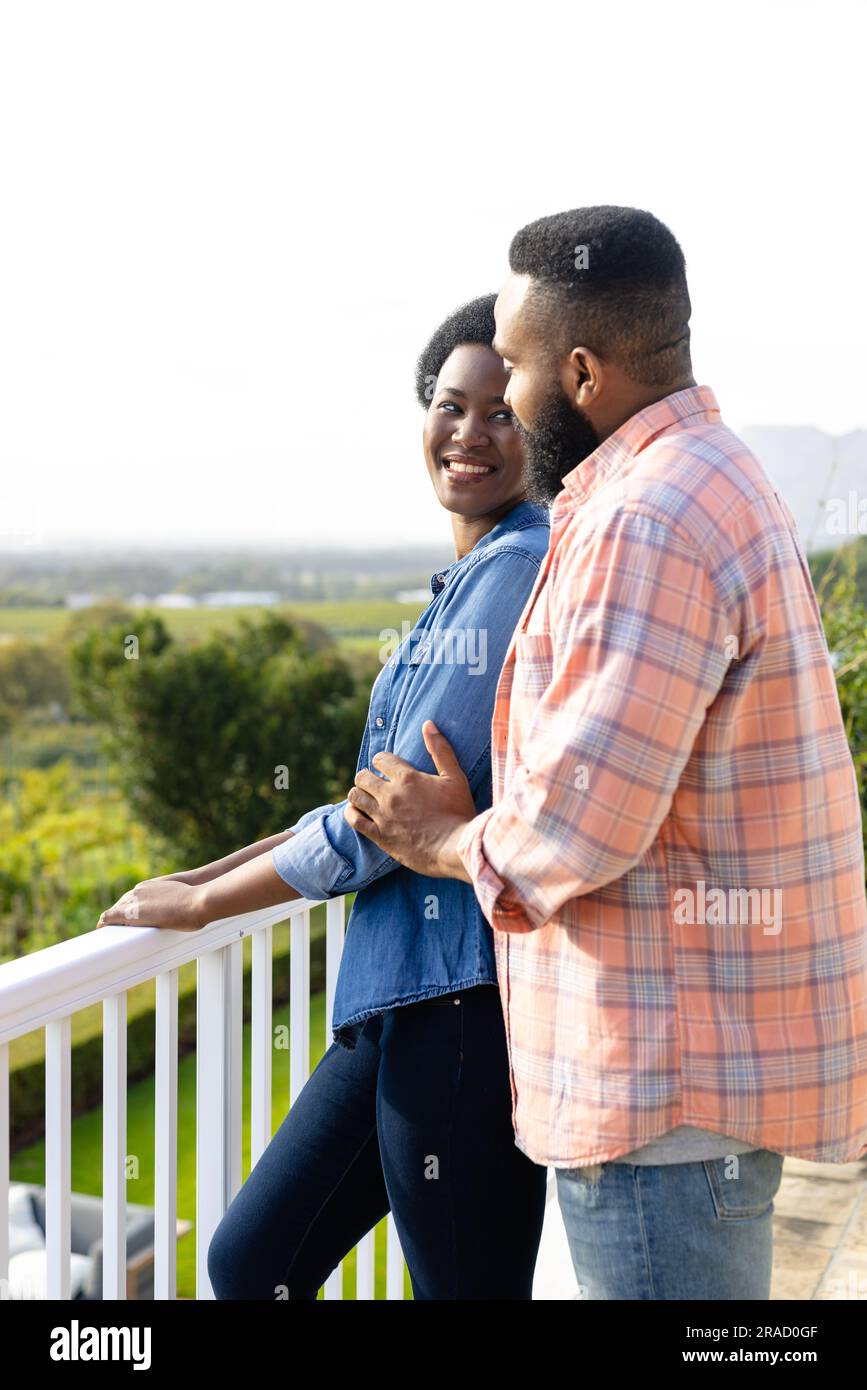 Happy african american couple embracing and staying on sunny terrace ...