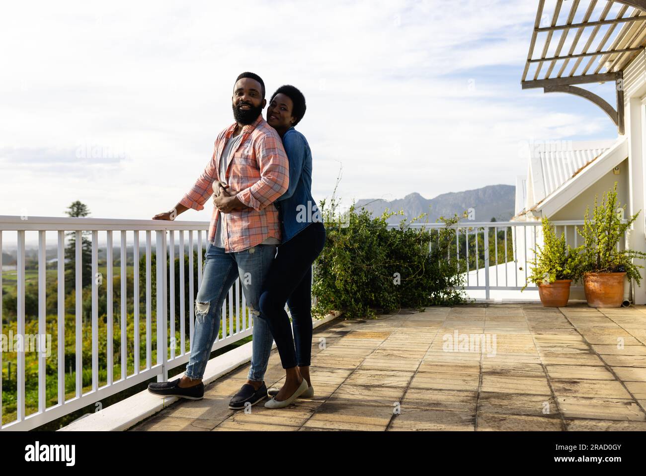 Happy african american couple embracing and staying on sunny terrace ...