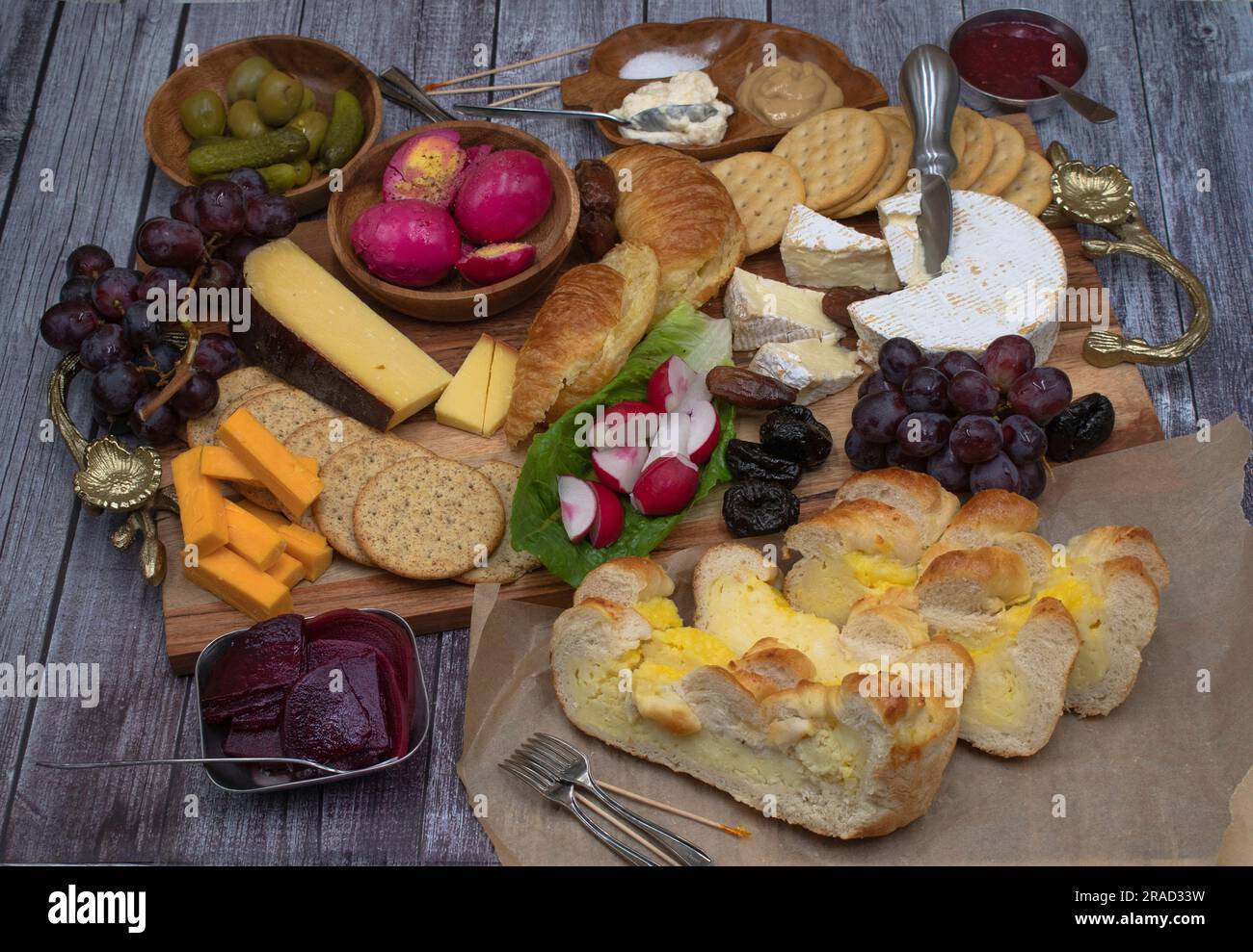 Vegetarian Easter brunch with various breads, eggs, cheese, fruit and cucumbers Stock Photo