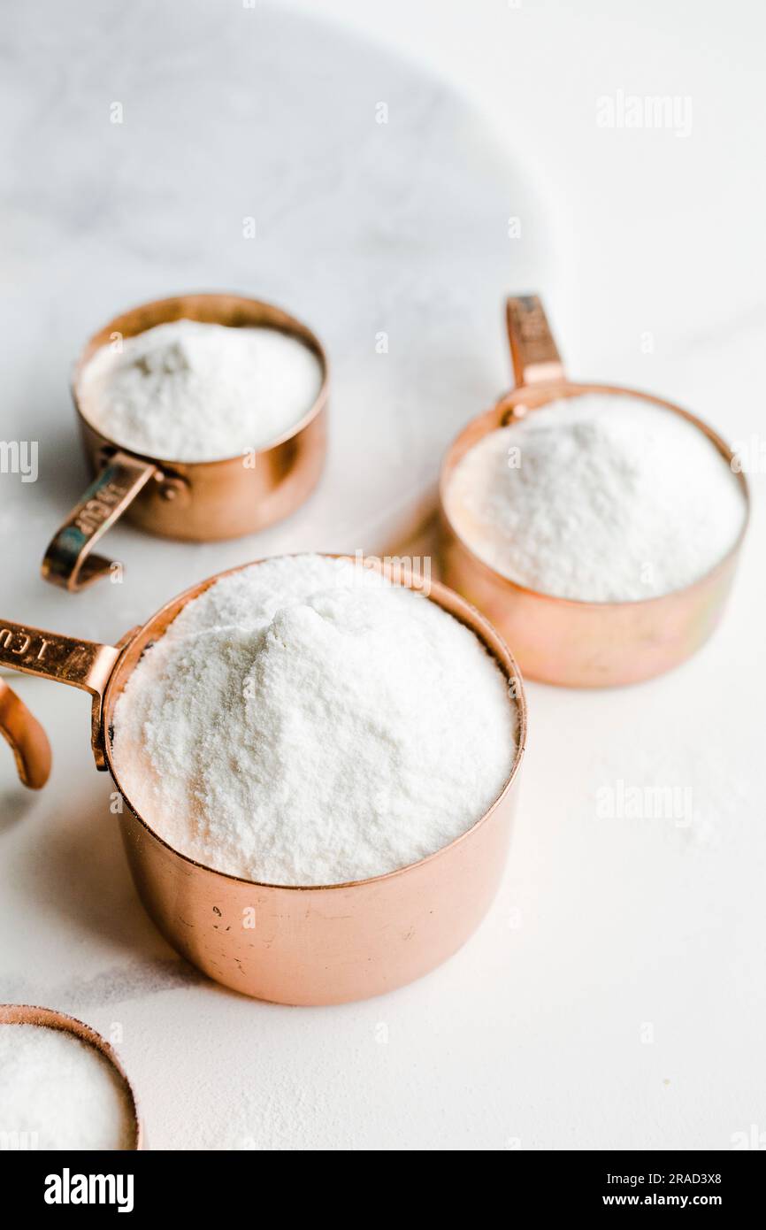 Measuring cups filled with white rice flour Stock Photo Alamy
