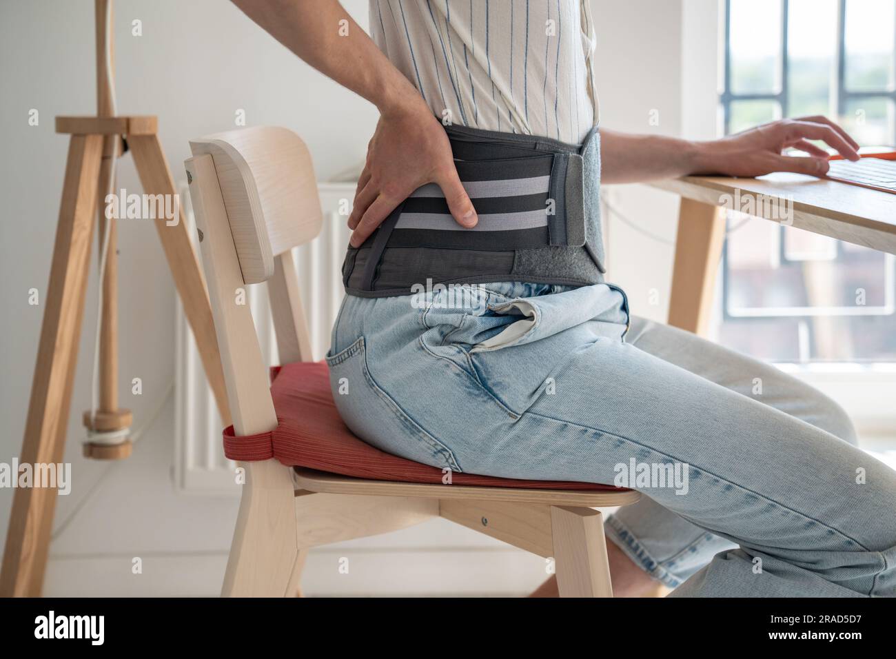 Man wearing back support belt on lower back during exacerbation to