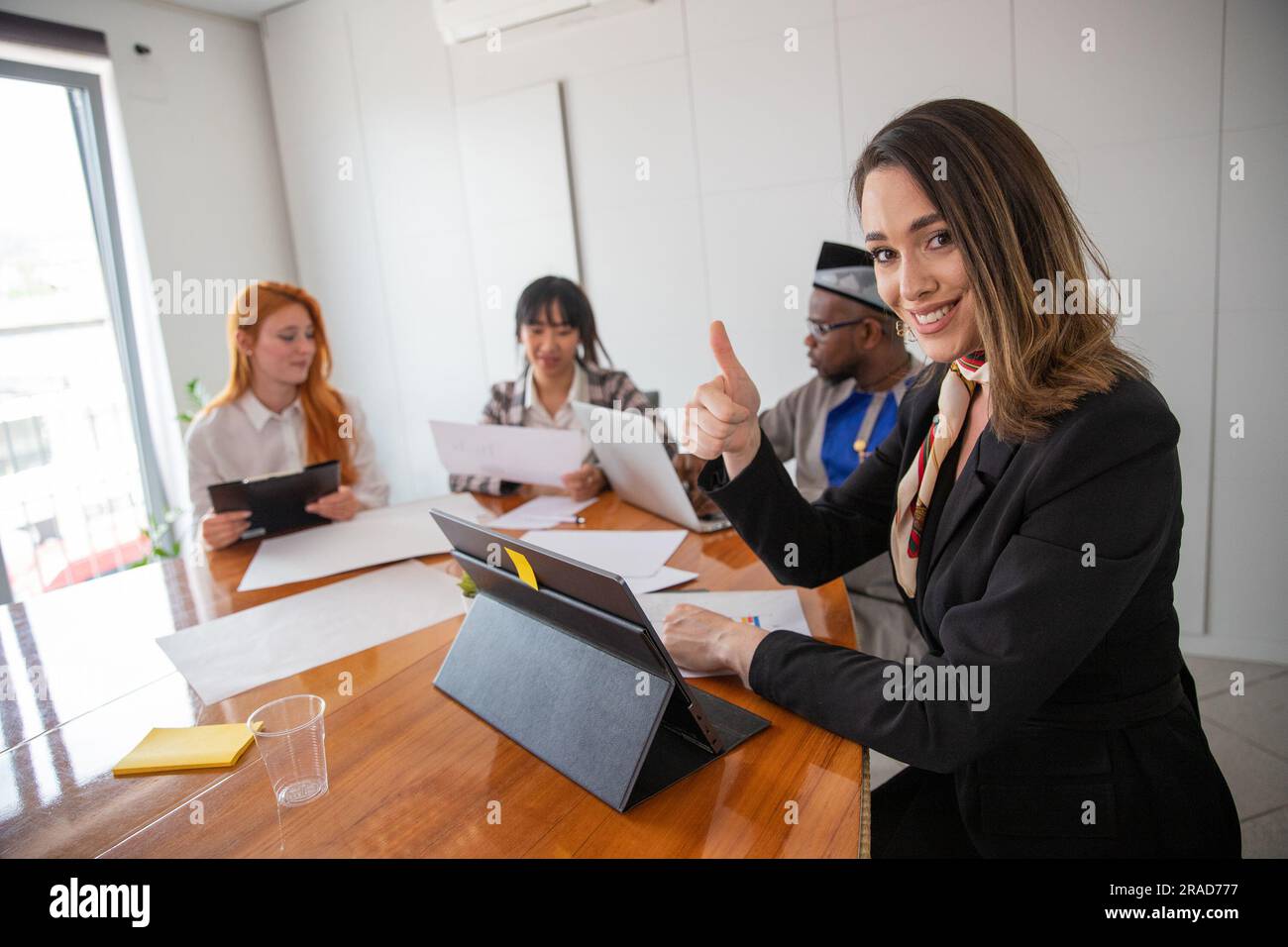 A businesswoman gives the thumbs up during a business meeting Stock Photo