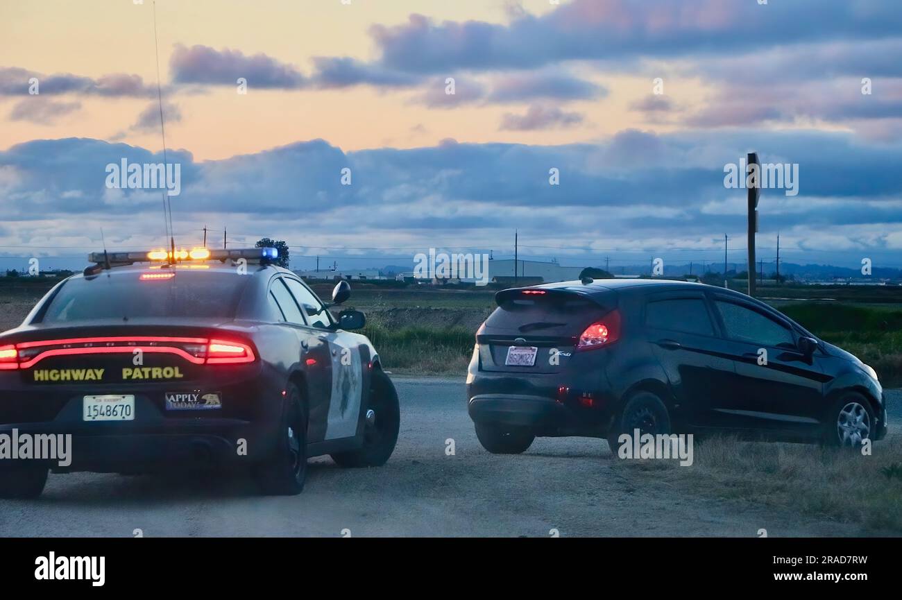 Highway patrol Dodge Charger police car pulls over a Ford Fiesta on the