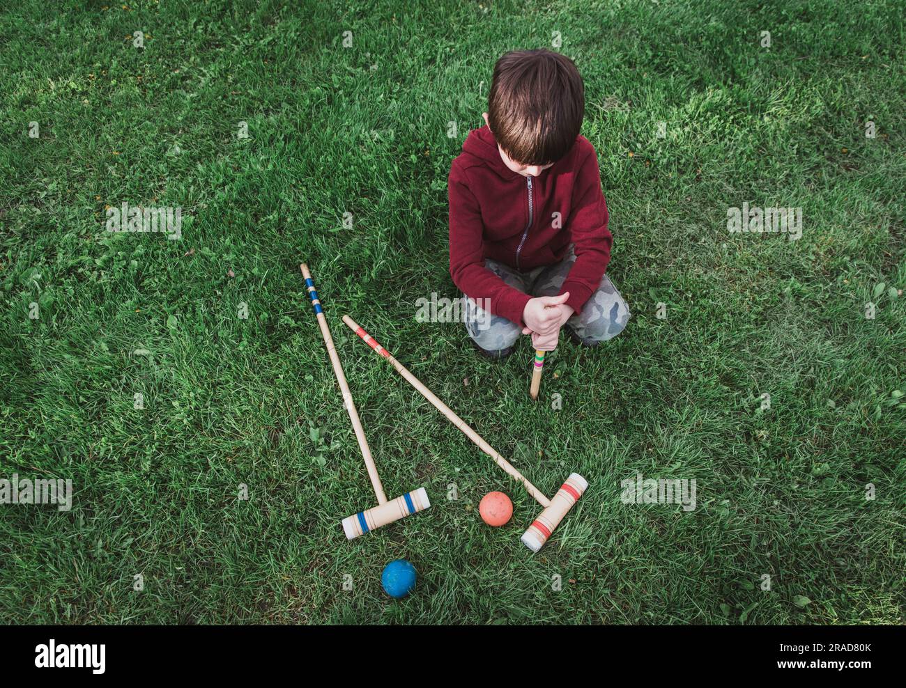 Young boy setting up a croquet game on the grass Stock Photo Alamy