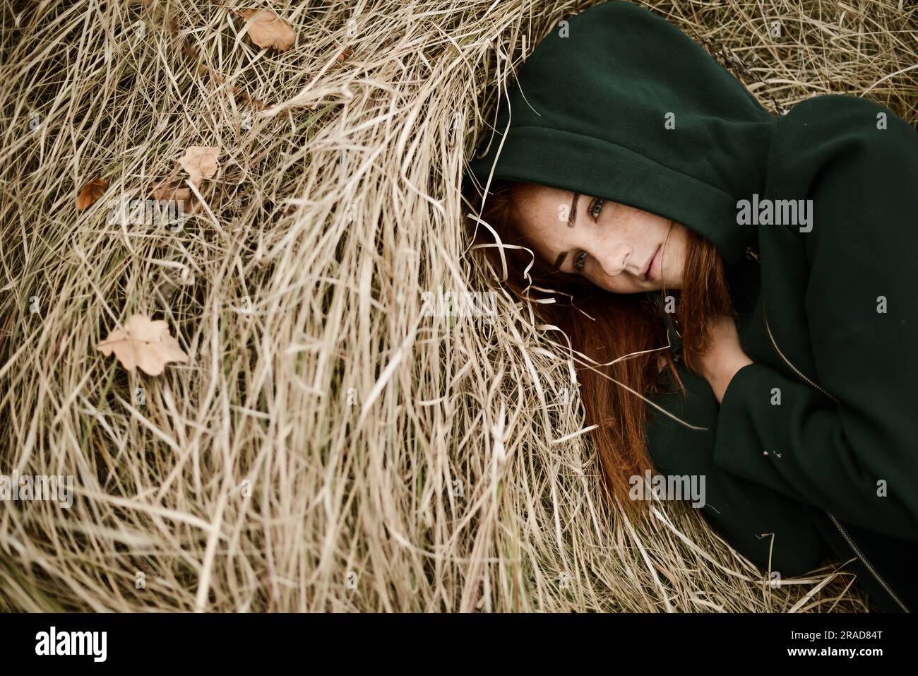 Close-up portrait of teenage girl with red head lying on grassy Stock Photo