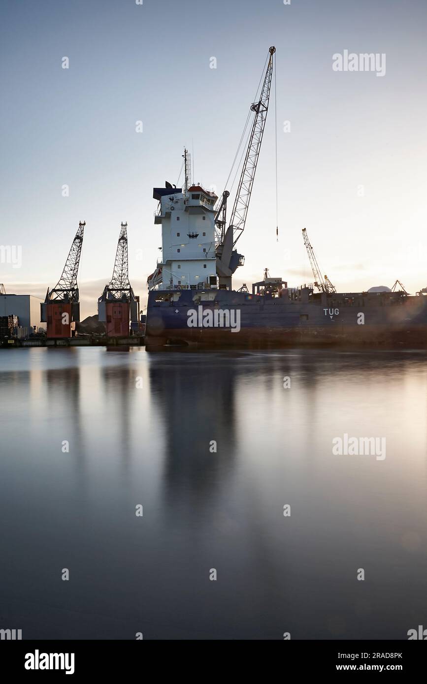 Cranes loading and unloading ships in the port of Rotterdam Stock Photo ...