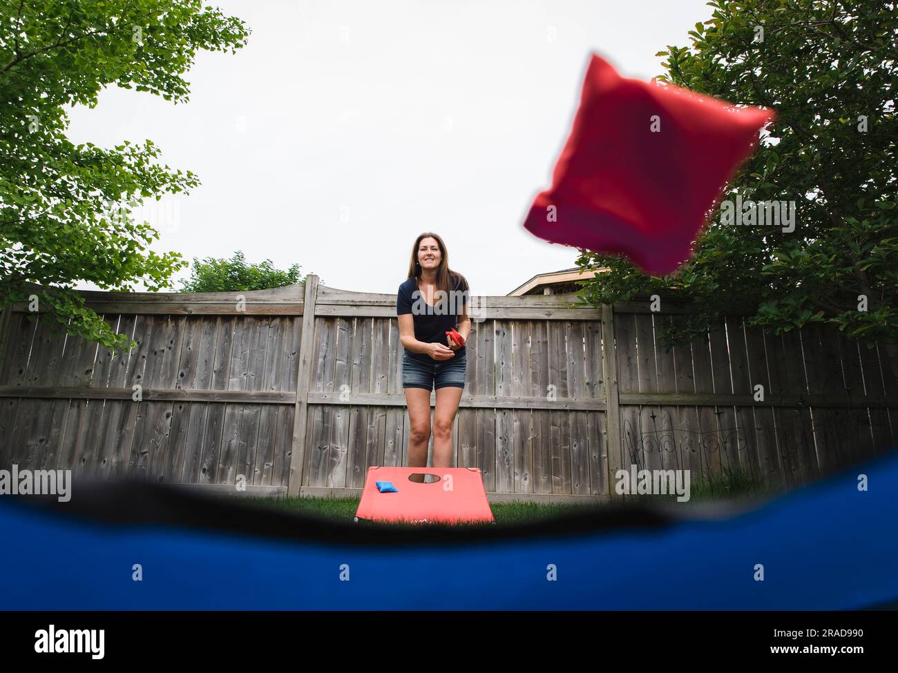 Woman throwing a bean bag in a corn hole game shot from below Stock ...