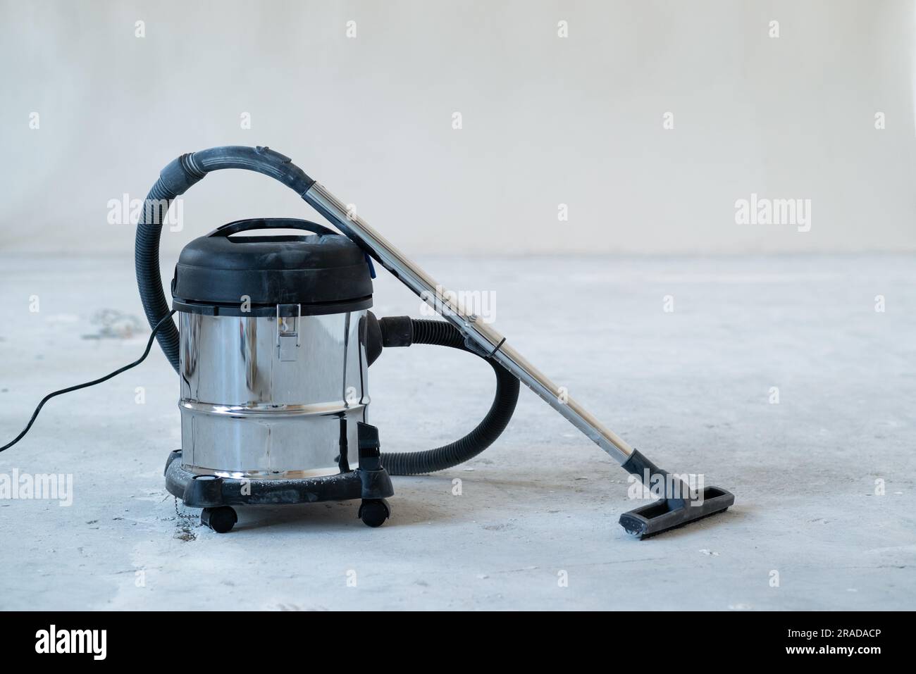 industrial vacuum cleaner at new house construction site, wide banner photo, space for text. Concept cleaning service and cleanup work. Stock Photo