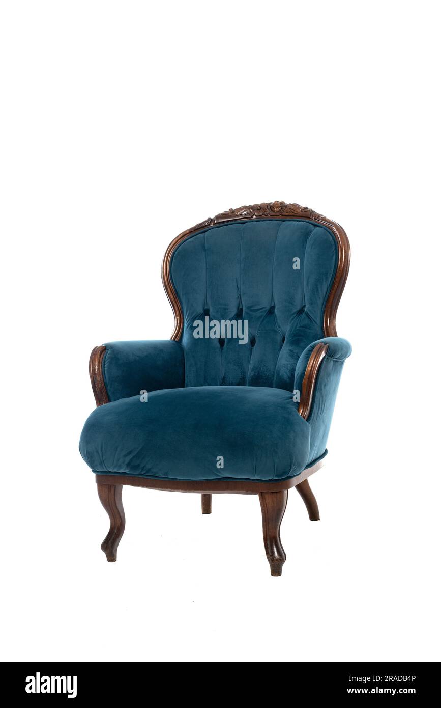 Old vintage velvet armchair with carved brown wooden frame and blue textile upholstery isolated on white background Stock Photo