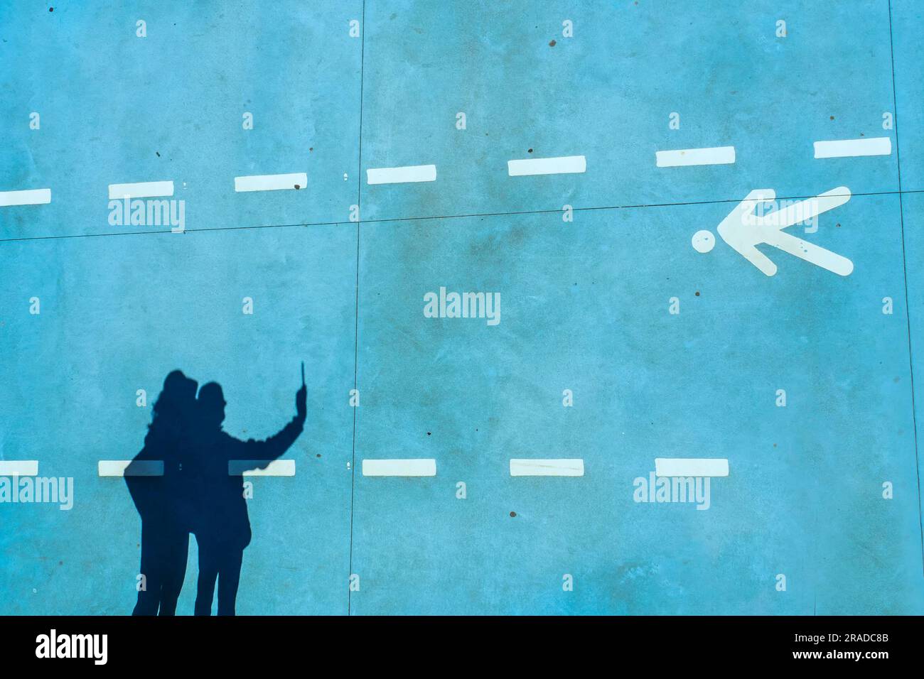 Silhouette of two people in a pedestrian lane in the port of Santander Stock Photo