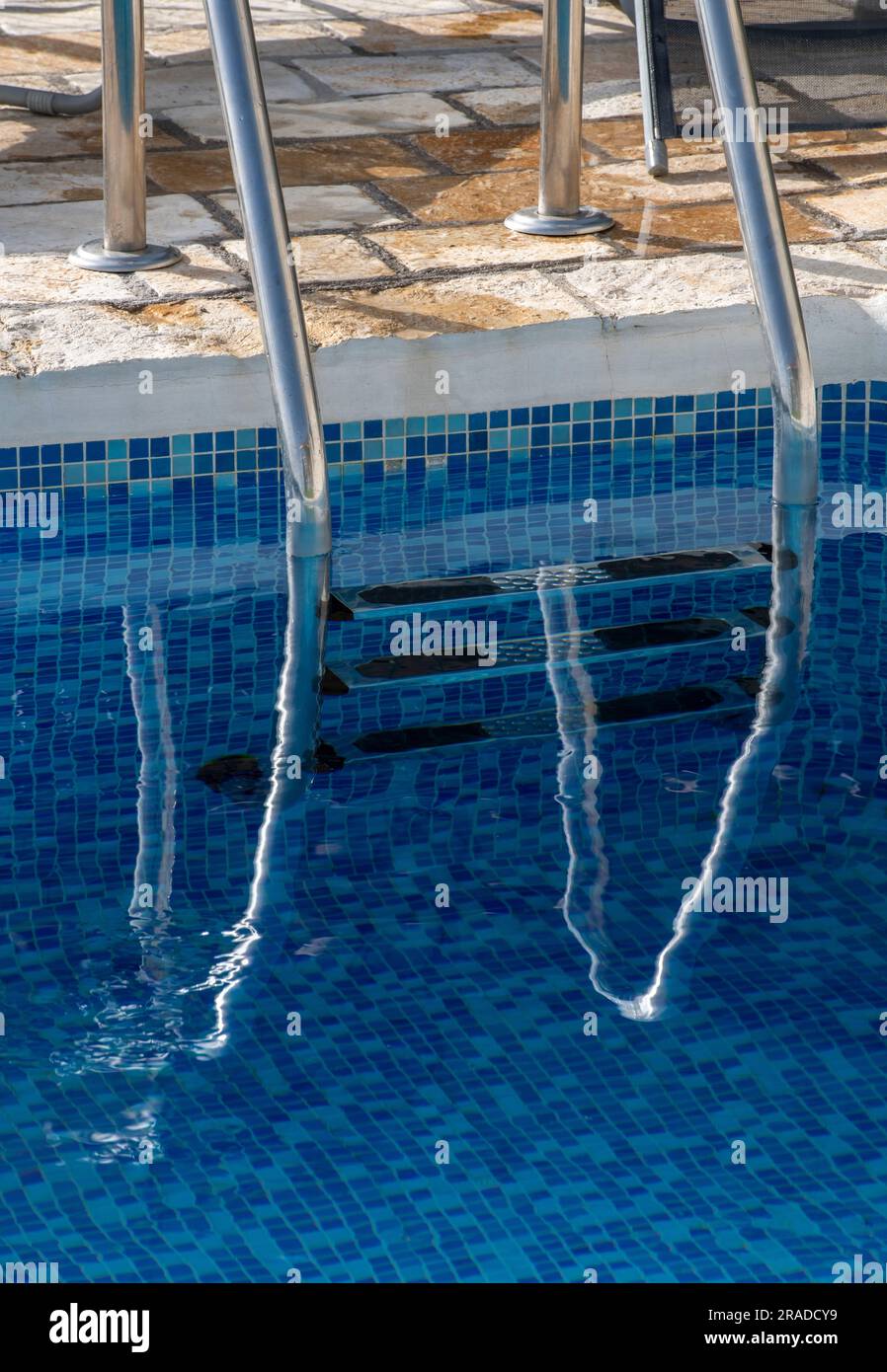 swimming pool steps closeup, chrome swimming pool ladder, blue water