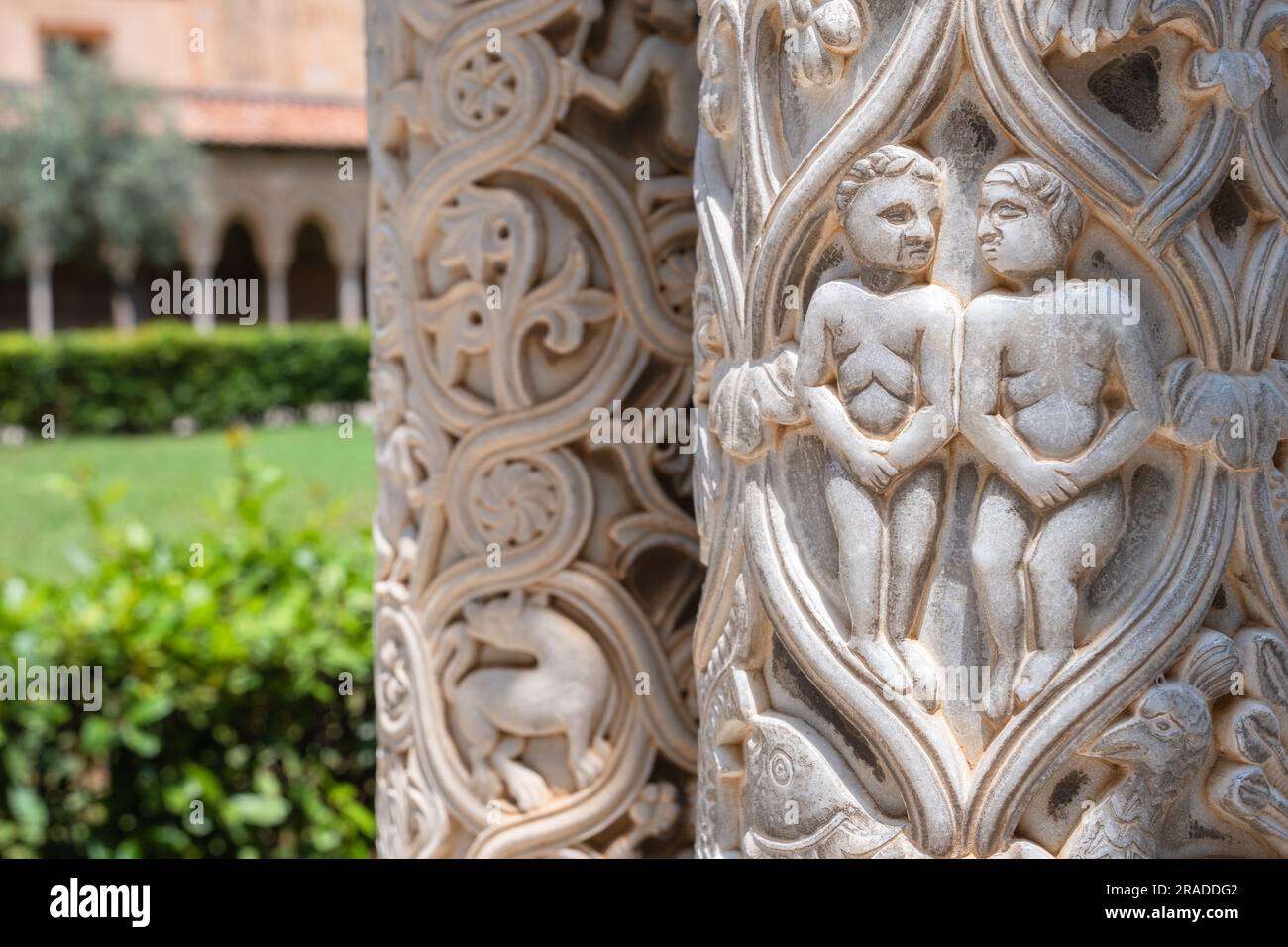 Relief with Adam and Eve on column, with garden in blurred background, Cloister of Monreale, Sicily Stock Photo