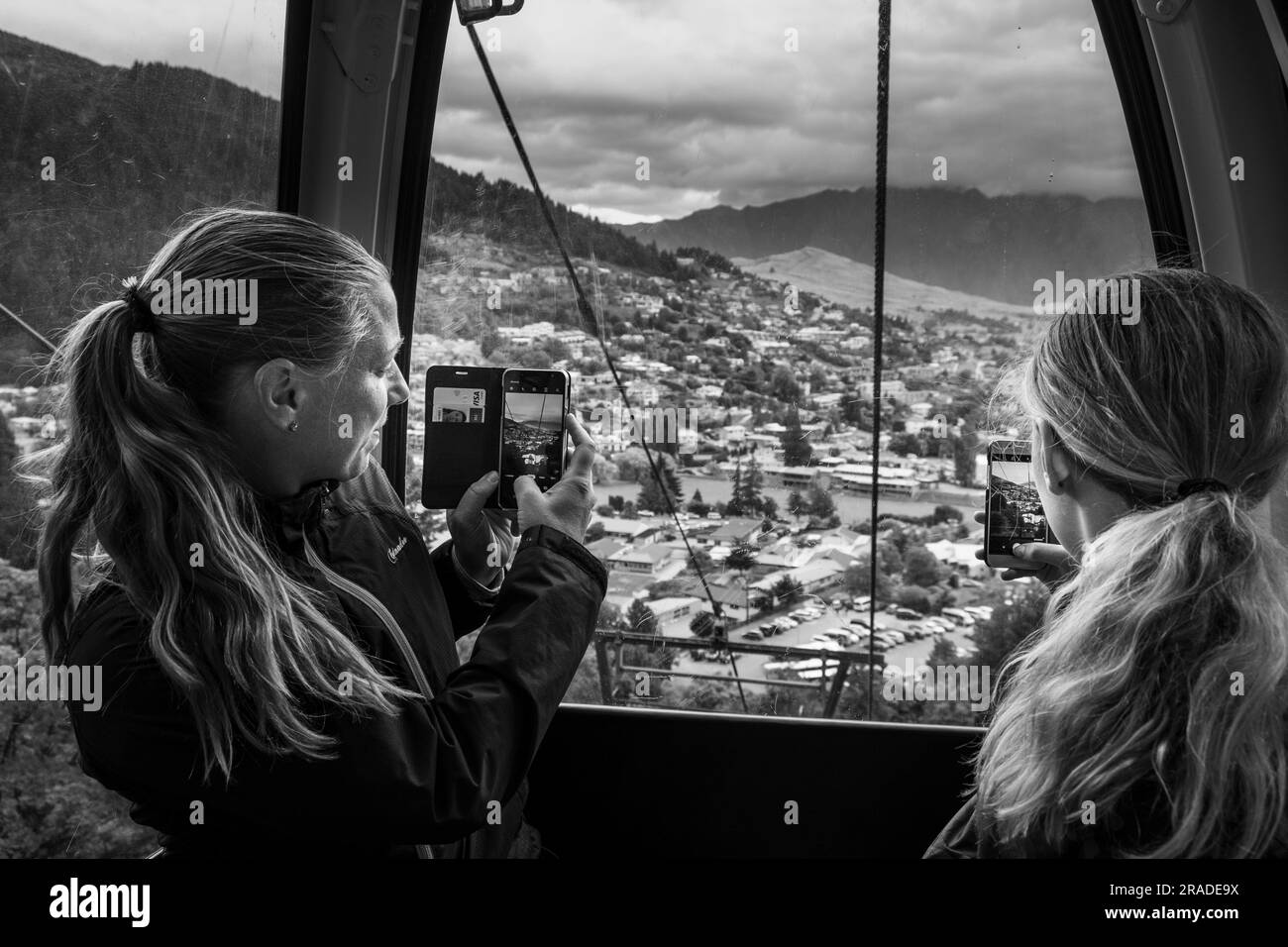 A mother and daughter take pictures in the cablecar up to Skyline Resort on Bob's Peak in Queenstown, New Zealand. Photo: Rob Watkins Stock Photo
